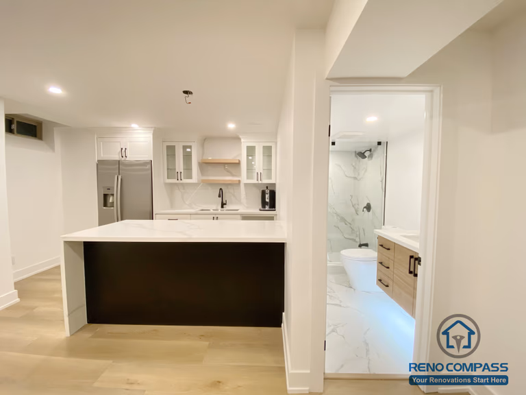 This modern basement kitchen includes a functional island layout, clean cabinetry, and efficient lighting. Designed to support entertaining and everyday use, the space seamlessly connects with the surrounding basement living areas.