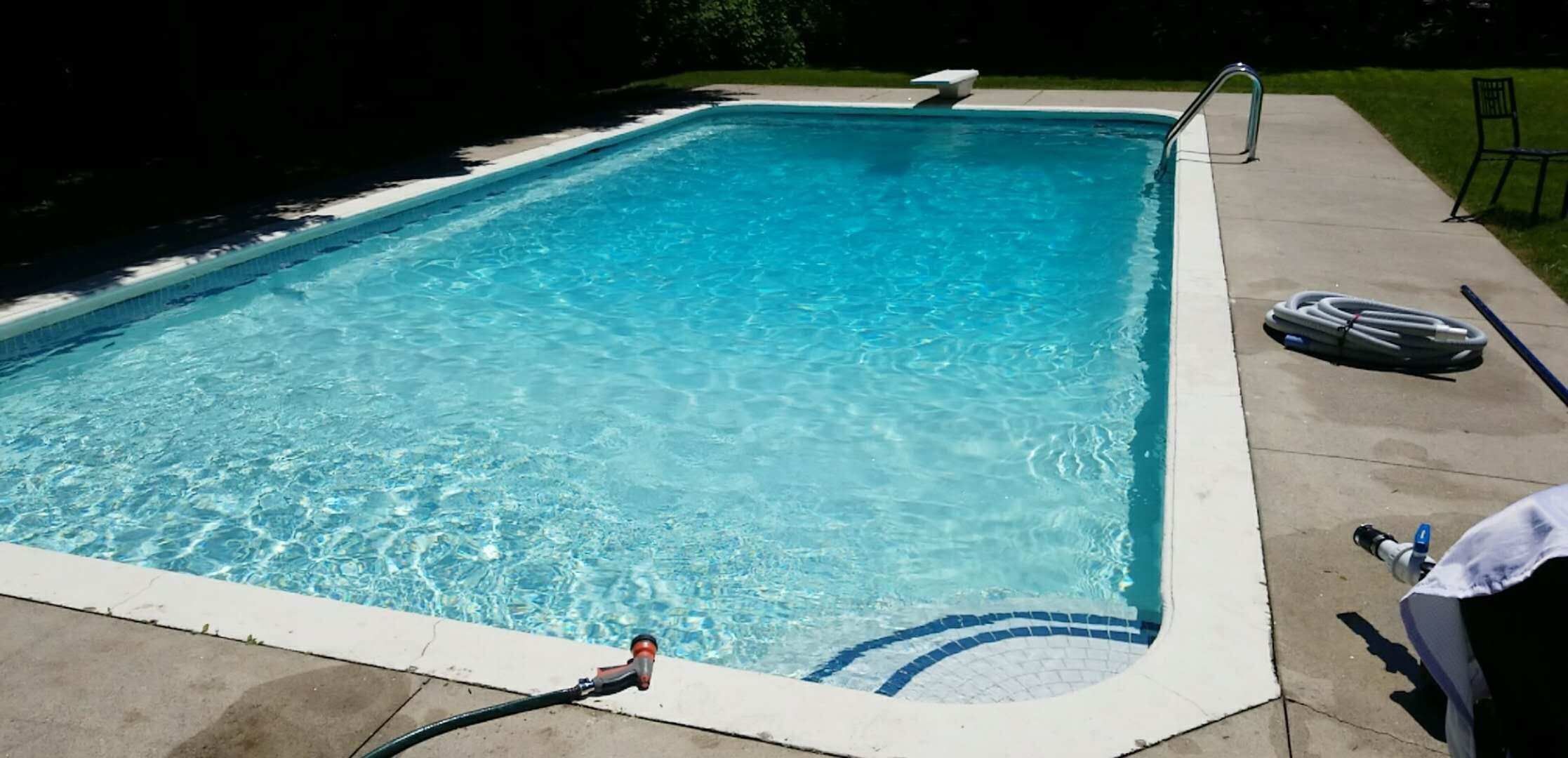 After renovation photo of a fully restored backyard swimming pool in Toronto. The new bright blue liner, clean water, and resurfaced edges highlight the professional pool transformation from old and damaged to modern and inviting. Expert pool renovation by local Toronto specialists.