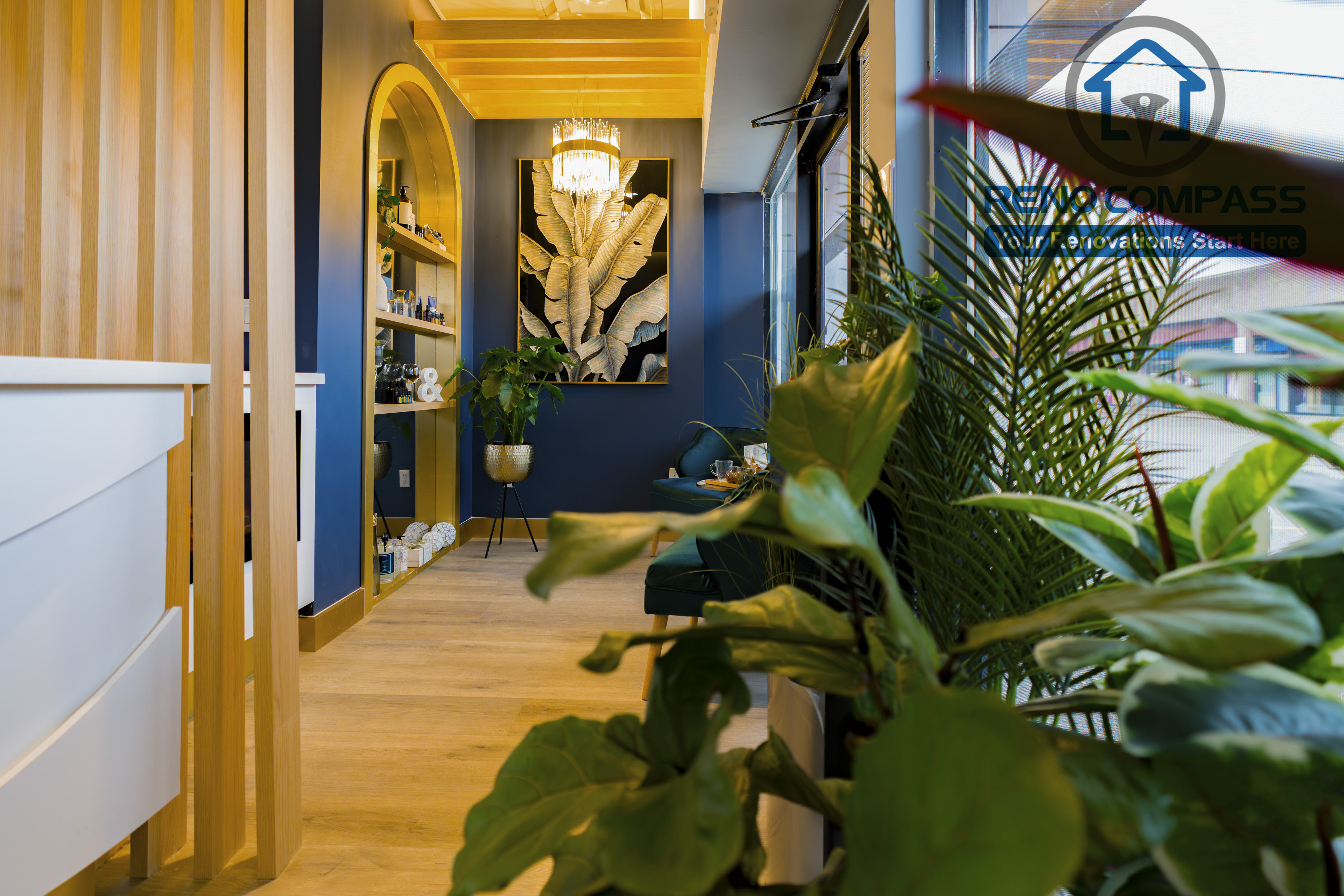 Waiting lounge completed as part of a North York beauty salon renovation. This space features comfortable seating, integrated product display shelving, warm ceiling lighting, and natural greenery that enhances a calm, spa-like atmosphere. Designed to improve client comfort and brand experience by a professional Toronto renovation company.
