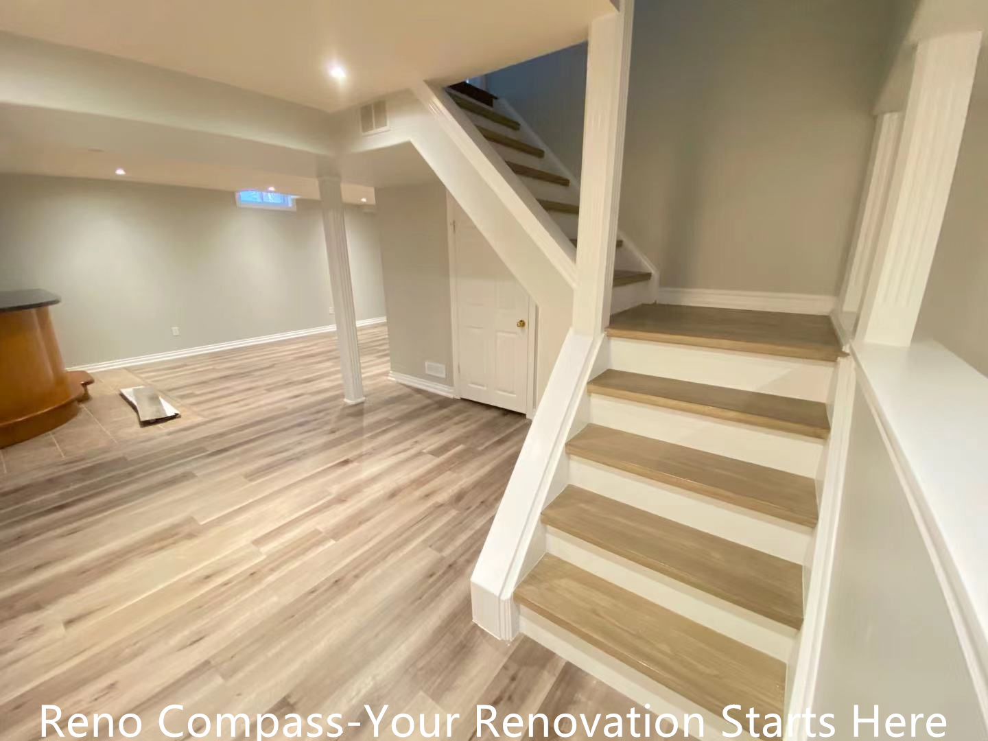 This Oakville interior renovation highlights a redesigned basement staircase that improves both circulation and visual continuity. The staircase features wood-look treads paired with crisp white risers and railings, creating a clean and modern contrast. By opening up the surrounding layout and integrating the stairs seamlessly into the basement space, the renovation enhances safety, flow, and overall spatial efficiency. Consistent flooring and recessed lighting further unify the basement environment, making it feel bright and inviting. This project reflects the thoughtful planning and craftsmanship delivered by a professional Toronto renovation company.