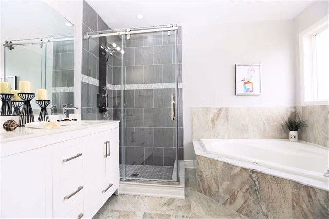 A beautifully remodeled bathroom featuring a frameless glass shower, sleek white vanity, and neutral tile design. Perfect inspiration for a modern home renovation in the Greater Toronto Area.