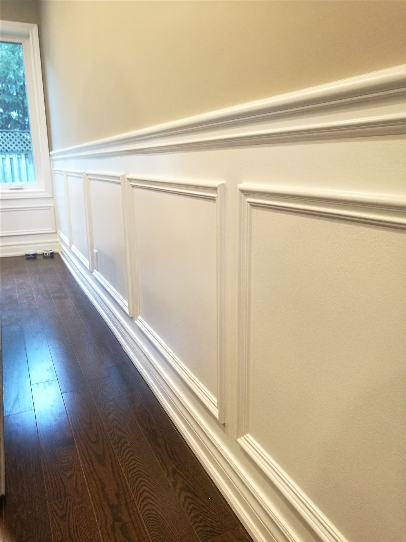 This Newmarket interior renovation features custom wall paneling and wainscoting with clean trim lines and precise detailing. Paired with dark hardwood flooring, the refined wall finish adds depth and elegance to the space, highlighting the craftsmanship and finish quality delivered by a professional Toronto renovation company.