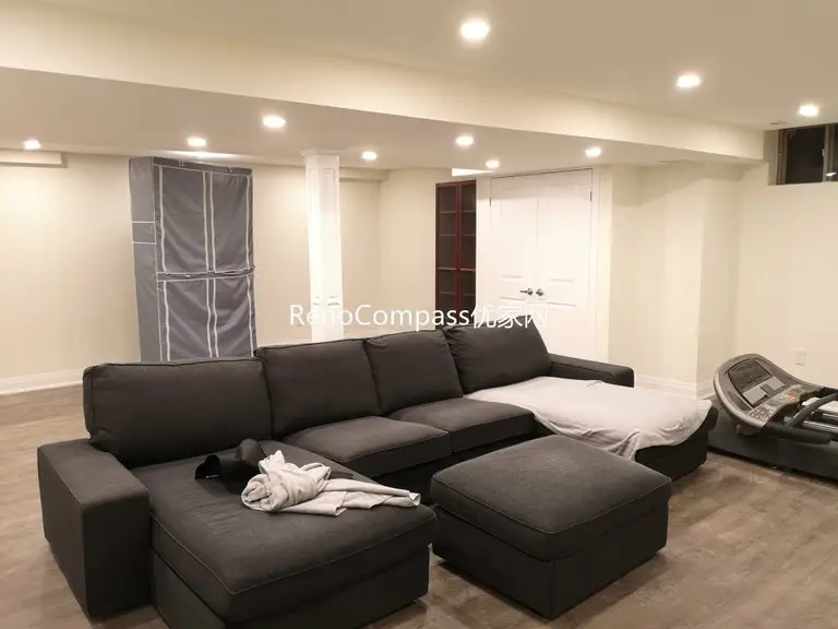 Spacious Richmond Hill basement entertainment area featuring open layout, sectional sofa lounge, upgraded flooring, and modern pot light ceiling design. Completed by Reno Compass Inc., this basement renovation creates a comfortable multi-purpose family and recreation space.