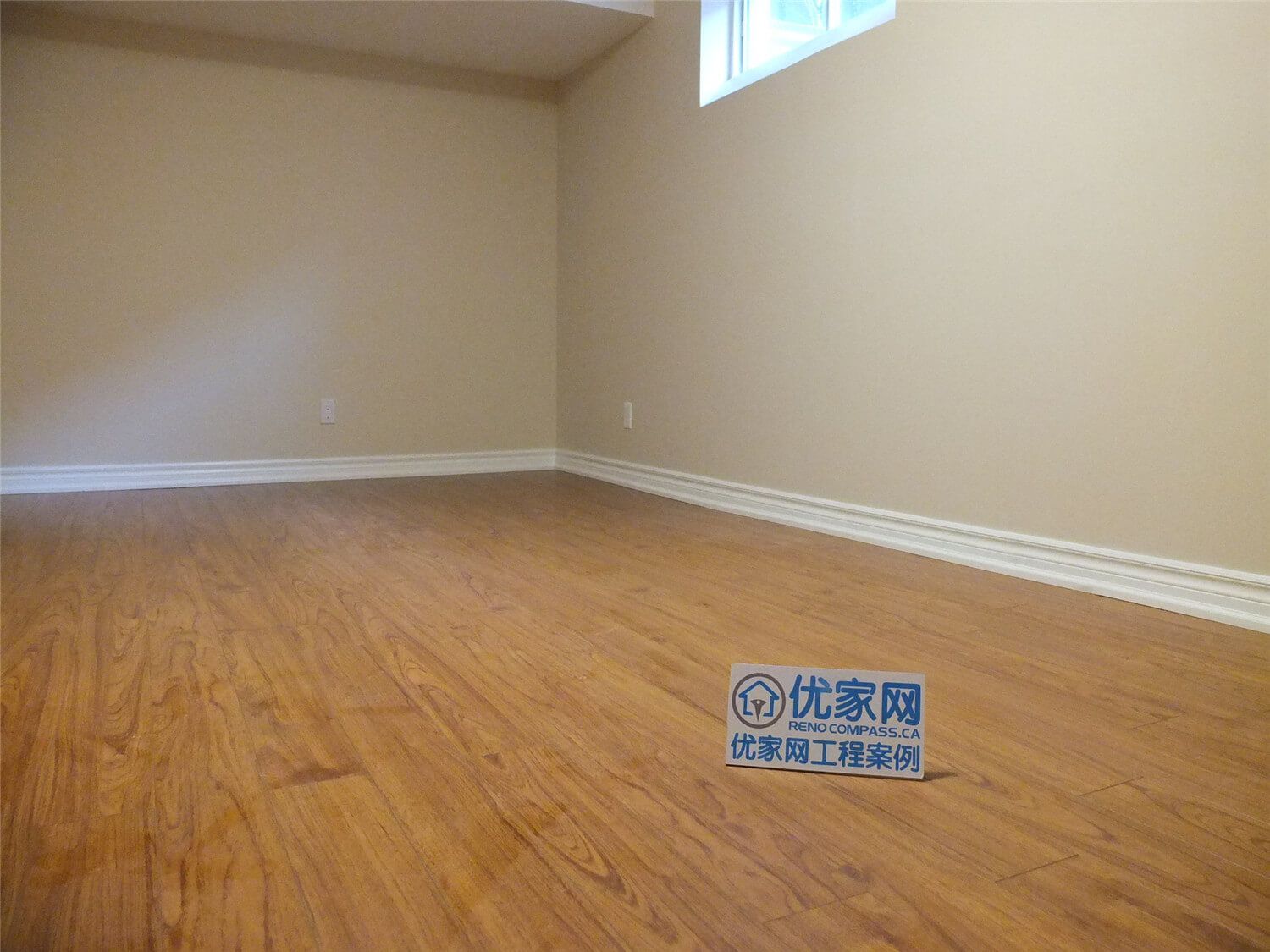 This Markham basement renovation project features newly finished walls, fresh interior painting, and durable laminate flooring installation. The clean wall finish, neutral paint tones, and wood-style flooring create a bright, comfortable living space suitable for a family recreation room or additional living area. Careful detailing around the baseboards and wall edges ensures a smooth and polished appearance throughout the basement interior.