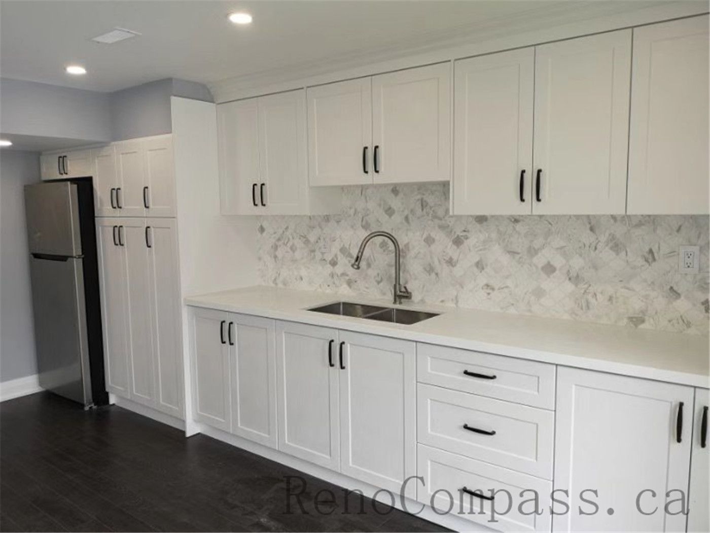 Stylish basement kitchenette renovation in Aurora with sleek white cabinets, gray countertops, and a clean, modern aesthetic. Designed by Reno Compass for convenience and visual appeal.