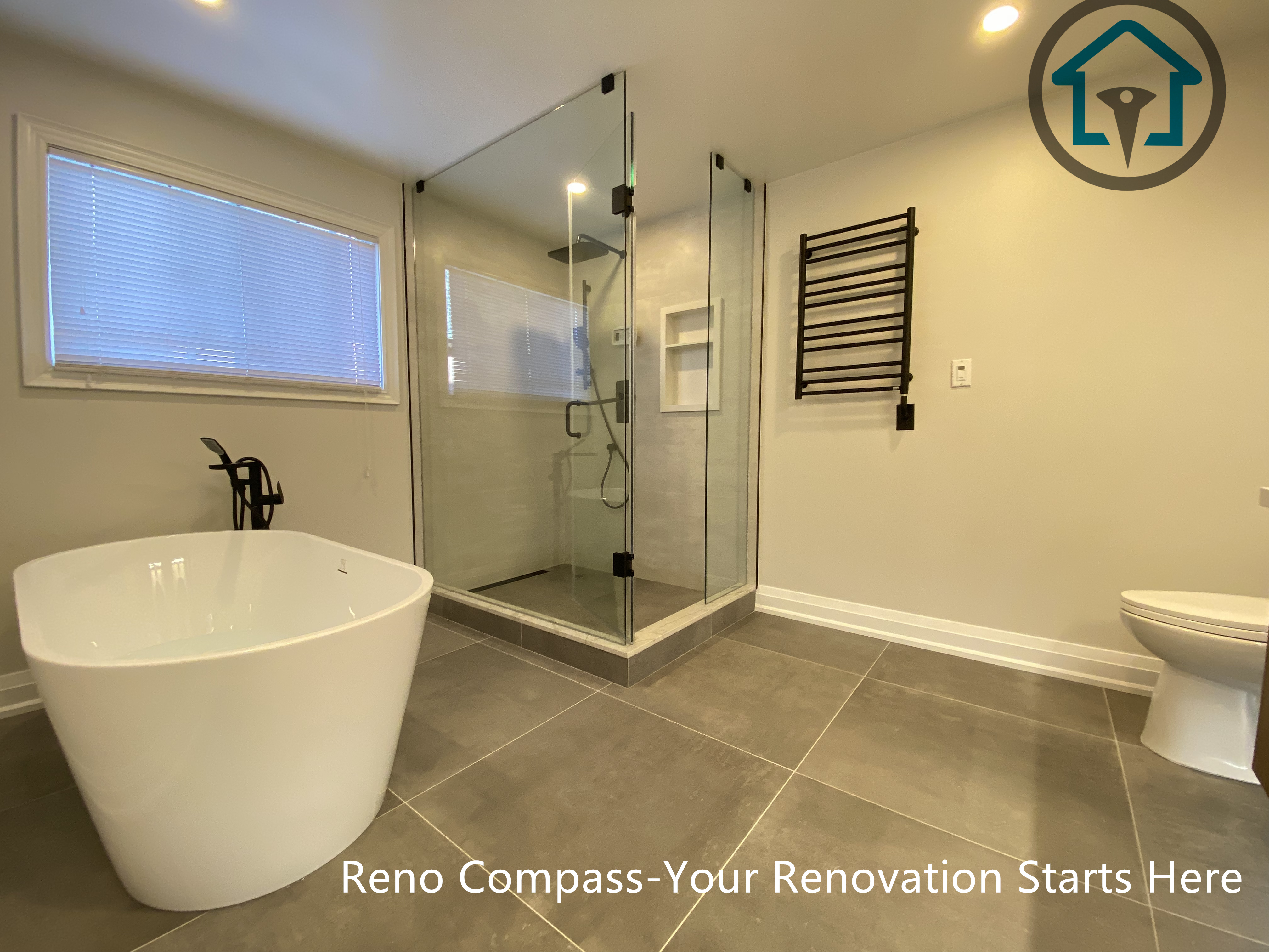 Spacious bathroom renovation in Markham featuring a frameless glass walk-in shower, freestanding soaking tub, large-format floor tiles, and modern matte black fixtures. The layout emphasizes comfort, functionality, and a clean contemporary aesthetic completed by a professional Toronto renovation company.