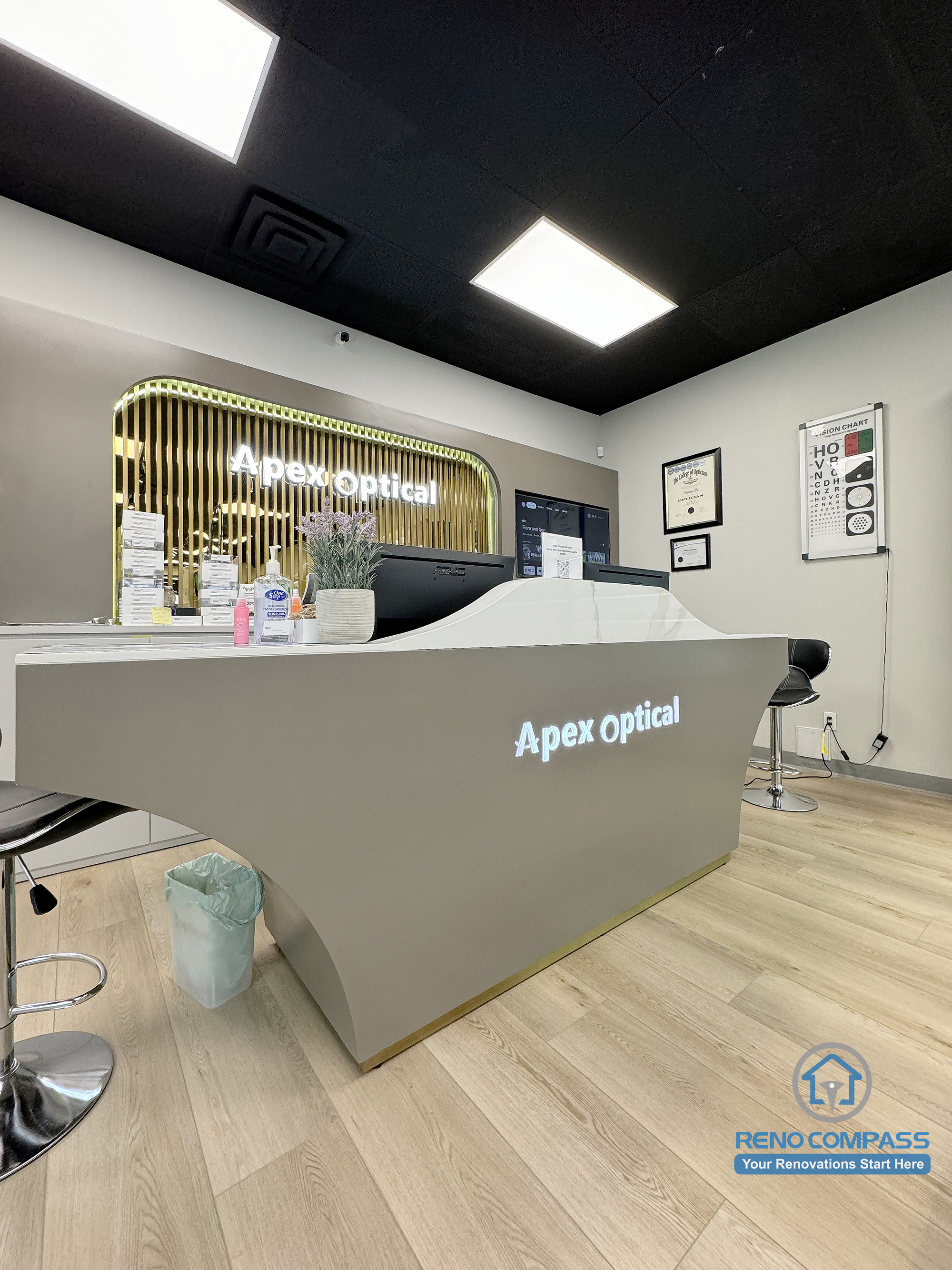 This Mississauga optical store renovation features a custom-designed reception counter with integrated branding, clean lines, and durable commercial finishes. The front desk area enhances customer interaction, staff workflow, and brand presence within a modern optical retail environment.