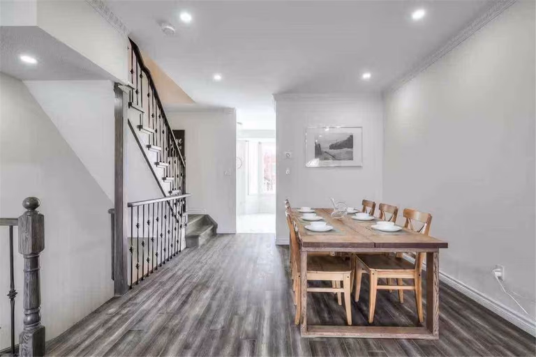 This Thornhill interior renovation features a spacious open-concept living and dining area with newly installed wood-style flooring, modern recessed lighting, and fresh neutral wall finishes. The upgraded staircase railings and clean layout enhance both functionality and visual appeal, creating a bright and welcoming home environment. Completed by a professional Toronto renovation team, this project highlights quality craftsmanship and modern interior transformation for comfortable family living.
