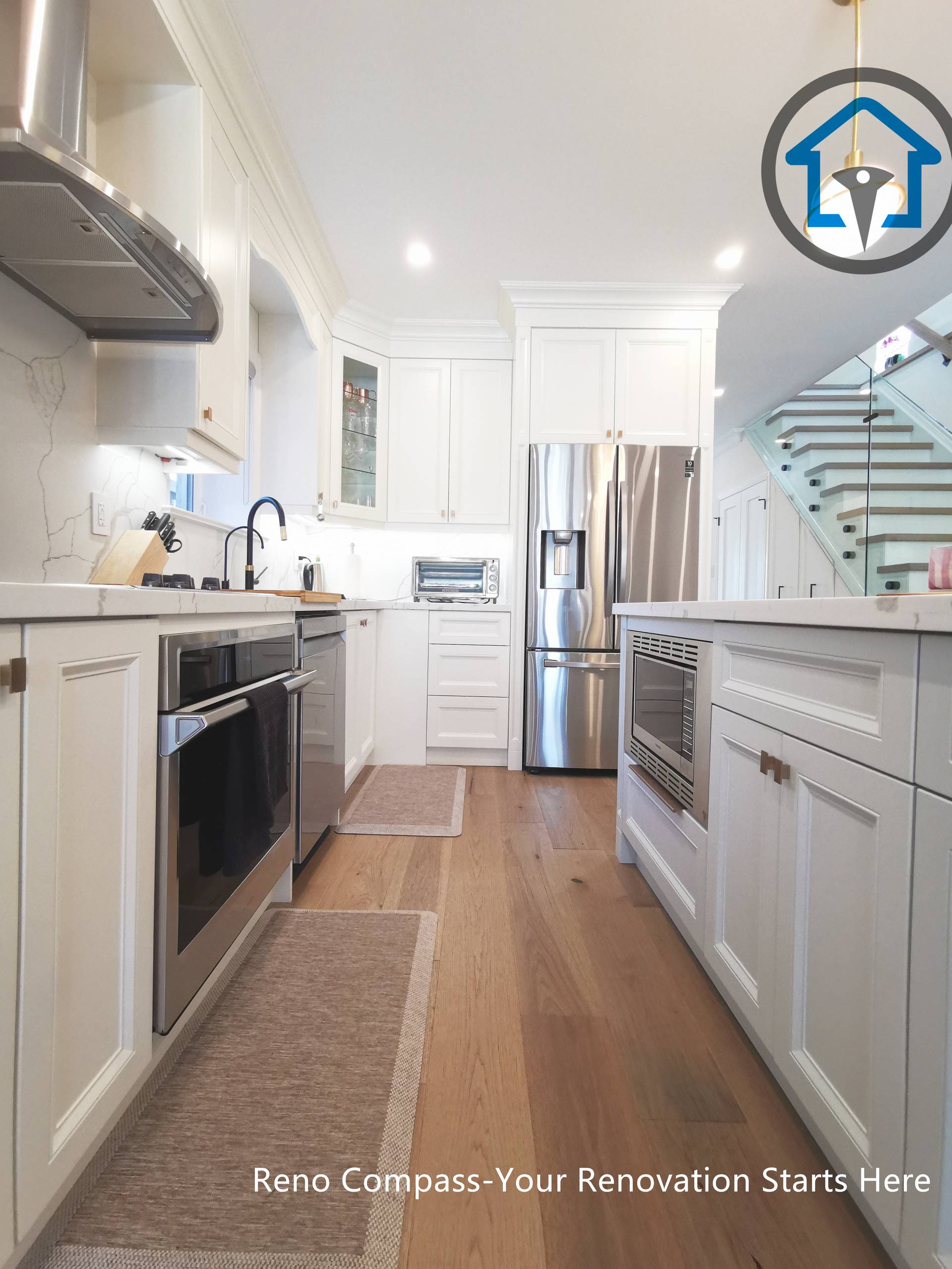 This image showcases a galley-style kitchen from a North York interior renovation, designed to maximize efficiency, storage, and clear circulation. Custom white cabinetry lines both sides of the space, paired with quartz countertops, stainless steel appliances, and integrated lighting for a clean and functional layout. Warm hardwood flooring softens the crisp finishes, while the extended sightline toward the staircase reinforces the open, connected interior design. Completed by a Toronto renovation company, this kitchen renovation highlights practical planning, balanced proportions, and long-term usability for North York homes.