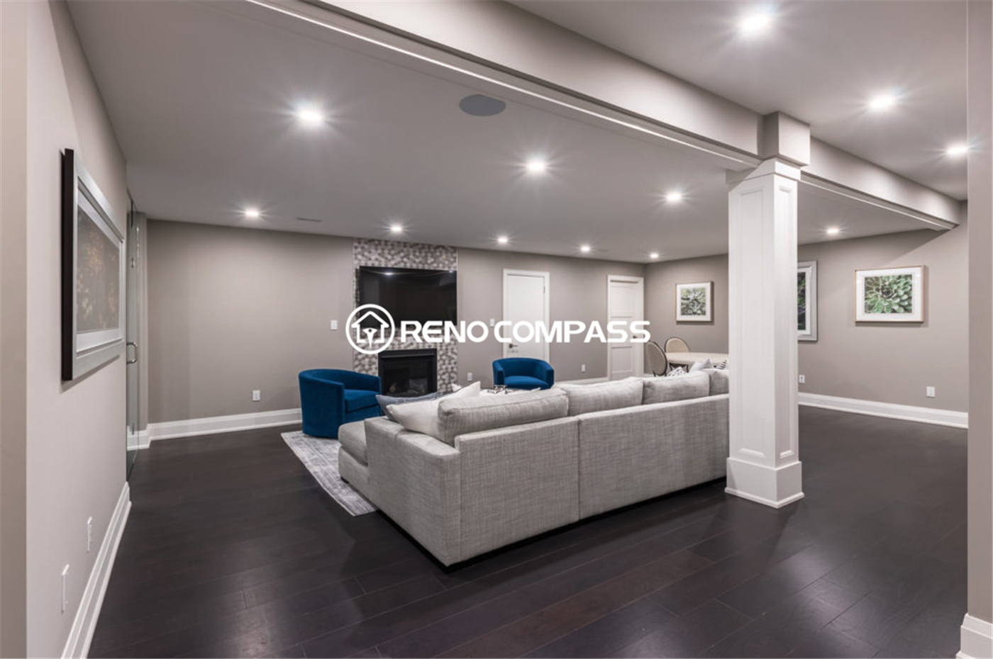 Spacious open-concept basement renovation in Toronto featuring modern recessed lighting, dark hardwood flooring, structural support columns, and a comfortable entertainment lounge area. This elegant basement living space was professionally designed and completed by a trusted Toronto renovation company, Reno Compass Inc.
