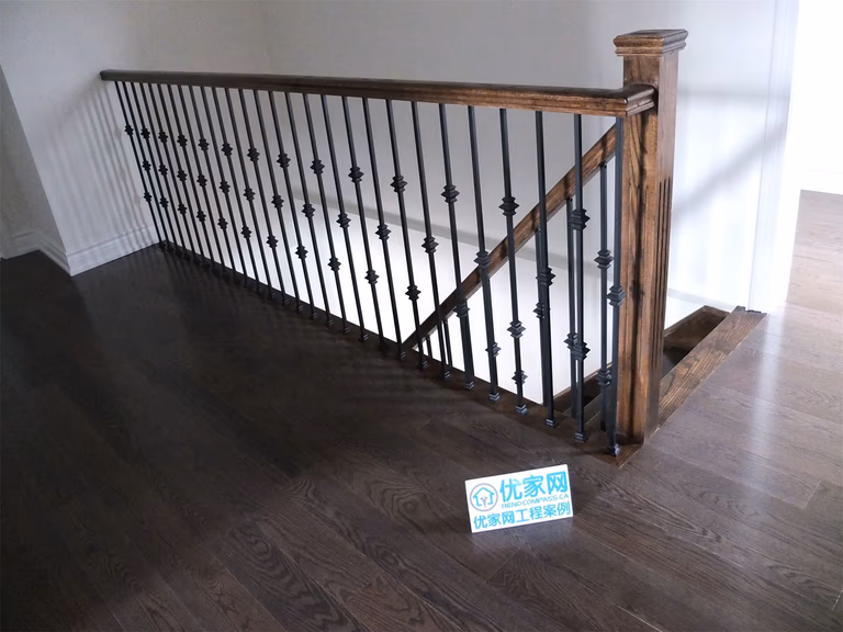 Upper-level staircase guardrail installation in a Scarborough home addition project featuring custom wood posts, decorative black iron balusters, and dark hardwood flooring. The renovation enhances safety and adds a modern architectural detail to the newly expanded interior space.