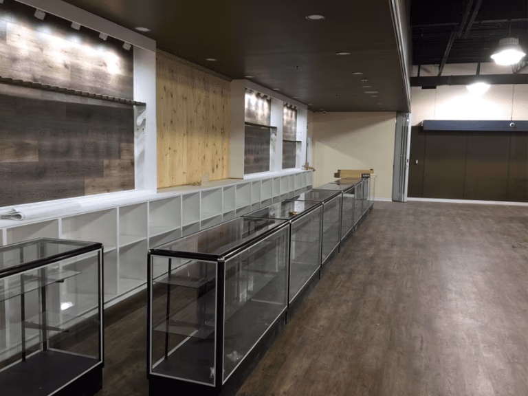 This outdoor retail store renovation features custom wall-mounted display panels, built-in shelving units, and modern glass showcase counters designed to highlight merchandise effectively. The upgraded vinyl flooring, clean ceiling finish, and strategic lighting layout create a professional and inviting shopping environment. Reno Compass Inc. delivered a functional commercial renovation that enhances product visibility, customer flow, and long-term durability for retail operations.