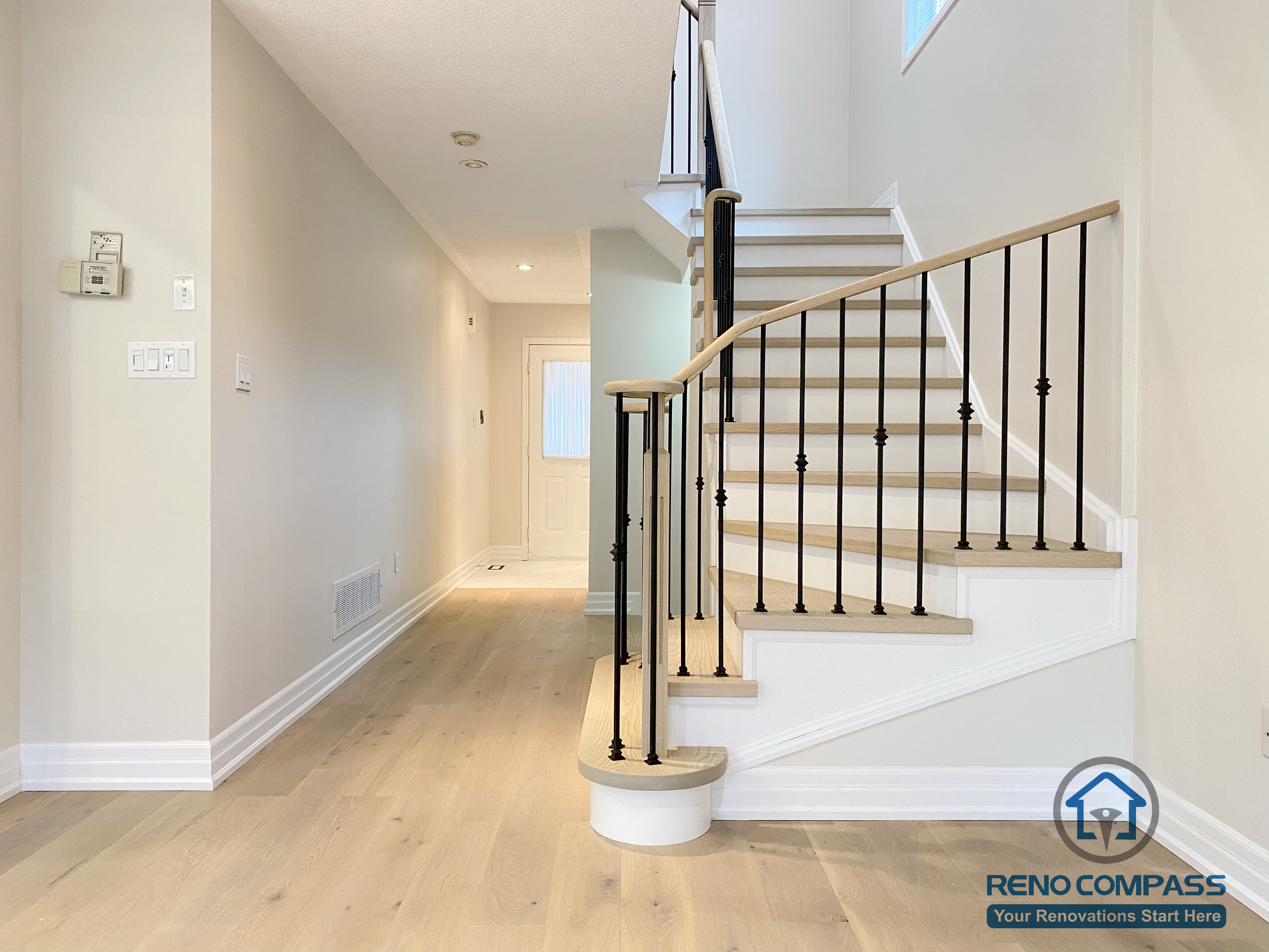 This Markham interior renovation features a modern staircase and hallway design with clean architectural lines and refined finishes. Hardwood stair treads, white risers, and black metal railings create a contemporary look, while wide-plank flooring and neutral wall tones enhance the sense of space and continuity. Thoughtfully placed lighting improves visibility and safety throughout the hallway. Completed by a professional Toronto renovation company, this renovation delivers a cohesive, elegant interior flow for a Markham home.