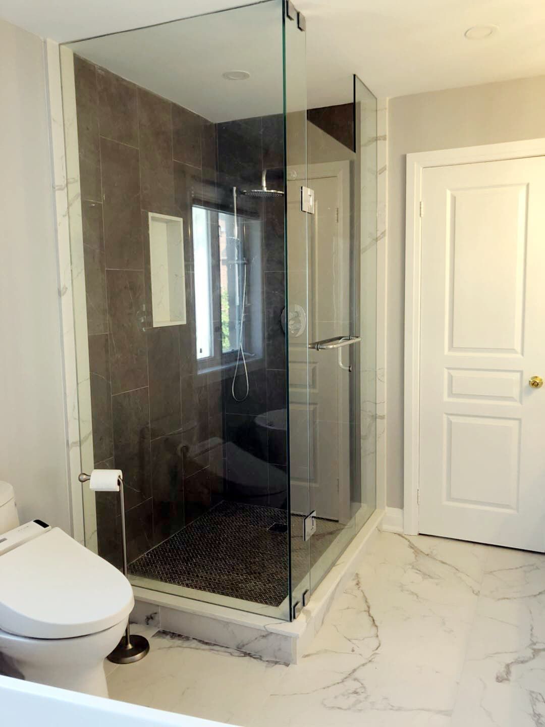 This Richmond Hill bathroom renovation showcases a sleek frameless glass shower enclosure paired with large-format wall tiles and marble-style flooring. The upgraded walk-in shower improves functionality and visual openness, creating a clean and contemporary spa-like environment. Modern fixtures, efficient layout planning, and durable finishes ensure long-term comfort and easy maintenance. Completed by a professional Toronto renovation company, this bathroom upgrade blends luxury design with everyday practicality for modern homeowners.