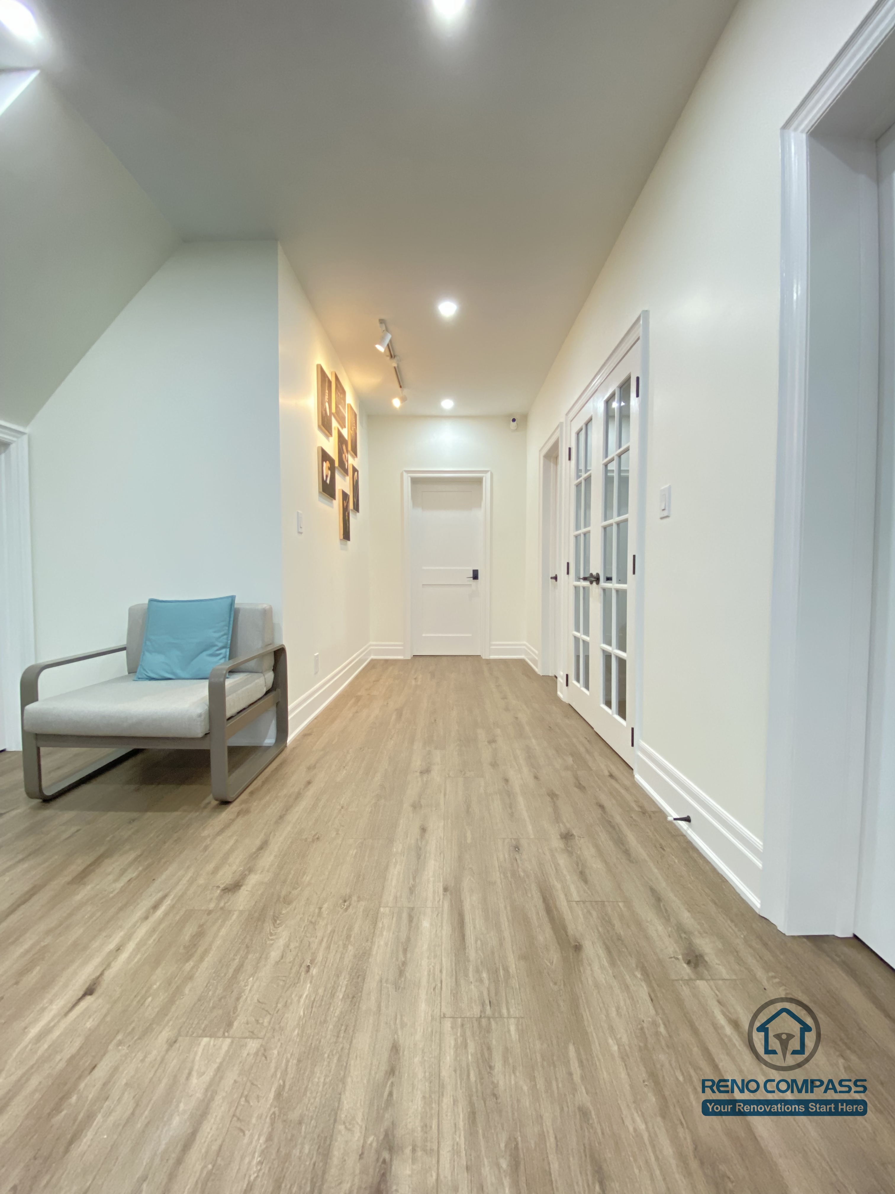 This Oakville basement renovation highlights a spacious, well-lit hallway that connects multiple functional areas with a clean and cohesive flow. Continuous wood flooring enhances visual depth, while recessed ceiling lights and glass-panel doors maintain brightness and openness throughout the space. Minimal furnishings and neutral finishes help define circulation without clutter. As a professional Toronto renovation company, Reno Compass designs basement layouts that prioritize movement, natural light distribution, and everyday comfort, creating lower-level spaces that feel open, organized, and inviting.