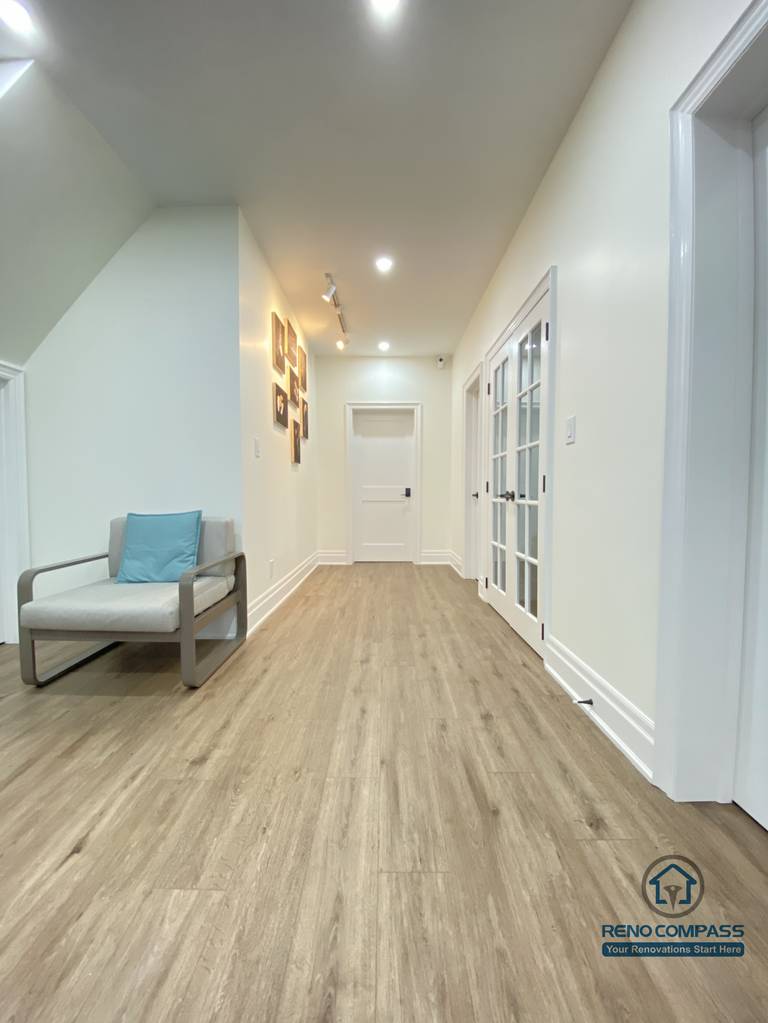 This Oakville basement renovation highlights a spacious, well-lit hallway that connects multiple functional areas with a clean and cohesive flow. Continuous wood flooring enhances visual depth, while recessed ceiling lights and glass-panel doors maintain brightness and openness throughout the space. Minimal furnishings and neutral finishes help define circulation without clutter. As a professional Toronto renovation company, Reno Compass designs basement layouts that prioritize movement, natural light distribution, and everyday comfort, creating lower-level spaces that feel open, organized, and inviting.