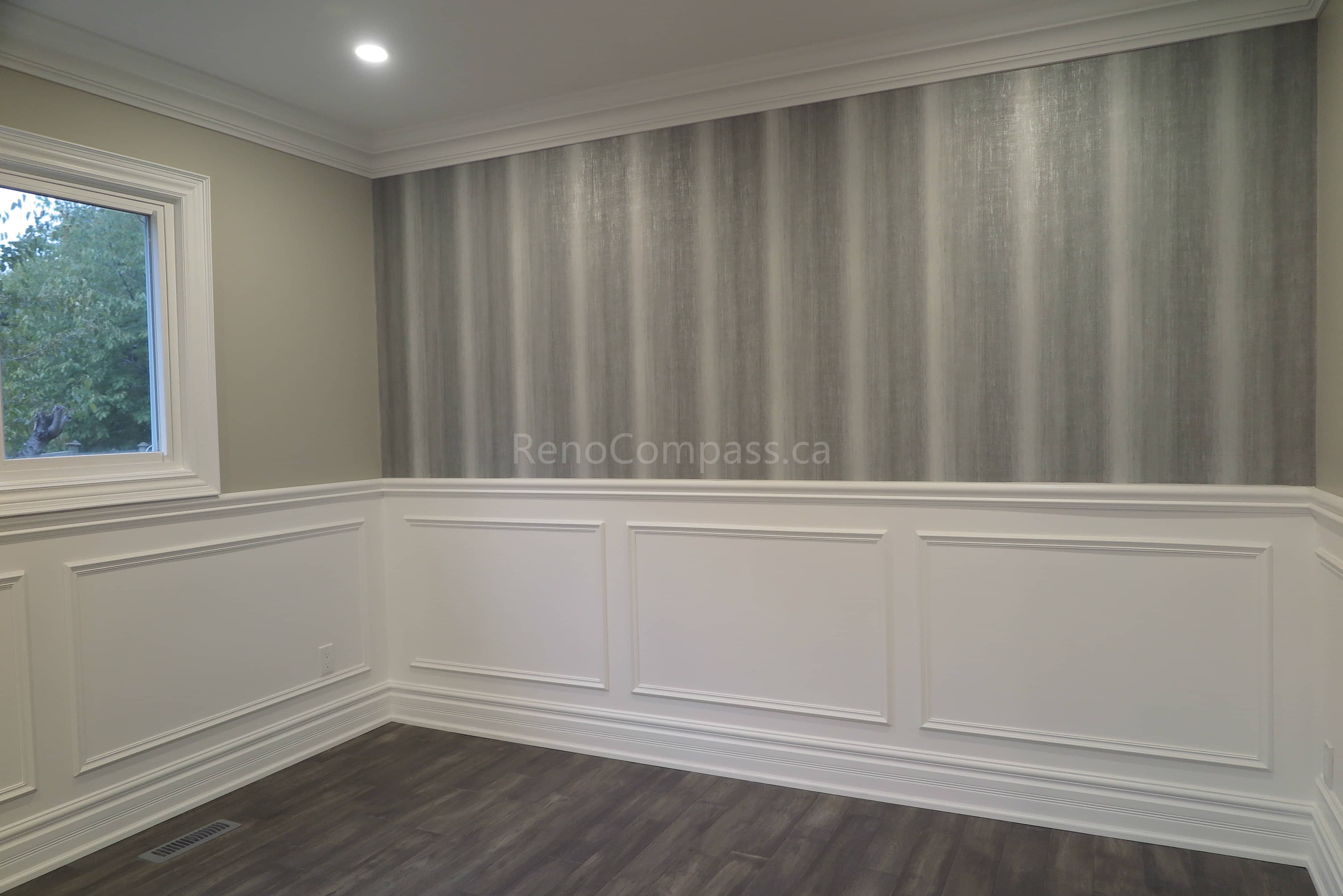 This Markham interior renovation project features elegant wall panel molding, modern grey accent wallpaper, and newly installed dark wood flooring. The space is enhanced with clean trim details, recessed lighting, and a refined contemporary design that elevates the overall home aesthetic. Completed by professional renovation contractor Reno Compass, delivering high-quality interior finishing and detailed craftsmanship in Markham and the Greater Toronto Area.