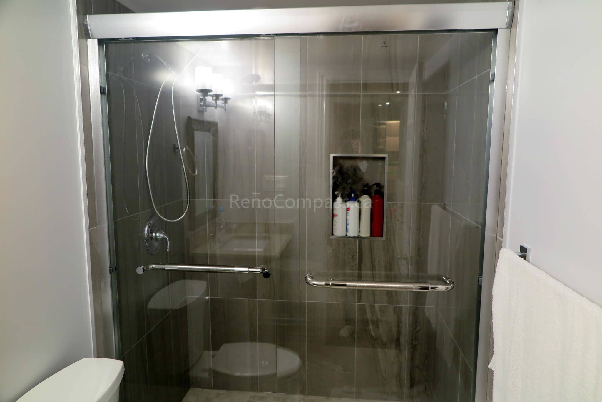 Upgraded basement bathroom in Richmond Hill showcasing a sleek glass-enclosed shower, contemporary wall tiles, and chrome fixtures for a spa-like atmosphere.