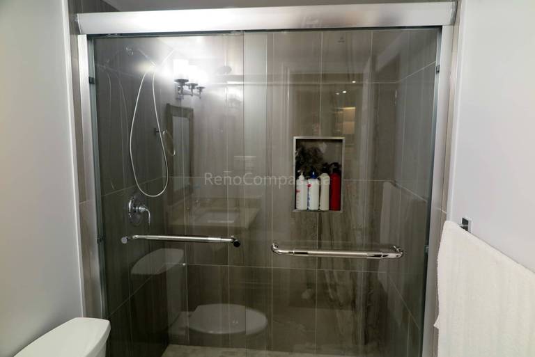 Upgraded basement bathroom in Richmond Hill showcasing a sleek glass-enclosed shower, contemporary wall tiles, and chrome fixtures for a spa-like atmosphere.