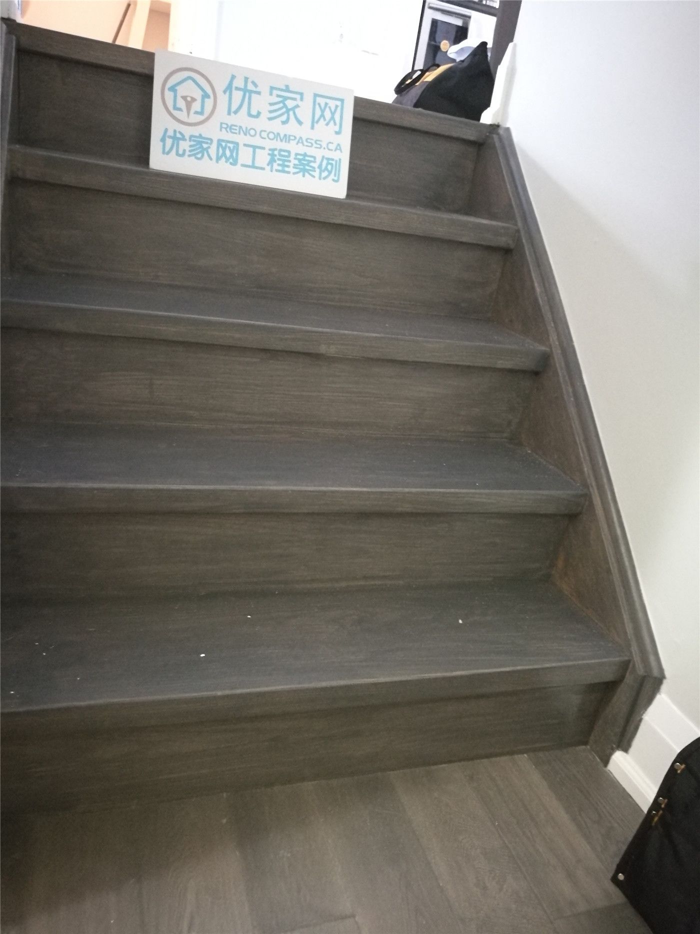 This Markham basement renovation features newly installed dark hardwood flooring and a refreshed staircase area, creating a clean, modern, and durable lower-level living space. Completed by Reno Compass Inc., the project enhances both functionality and visual appeal for everyday comfort.
