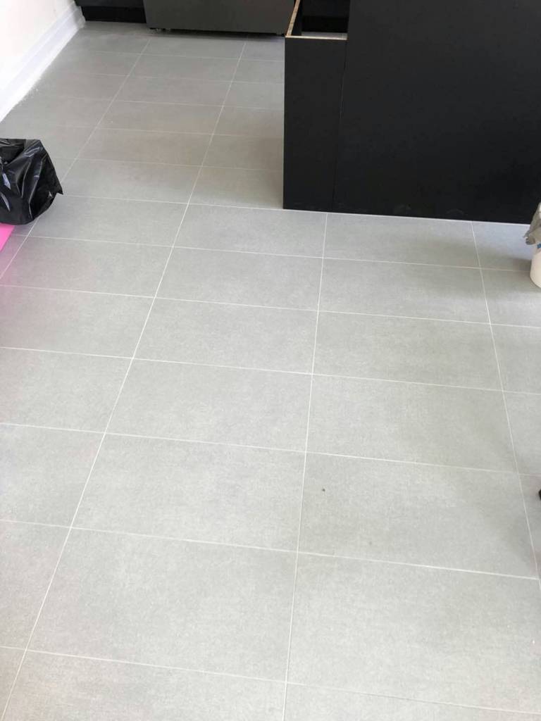 Light grey tile flooring installation in a Toronto interior renovation project. Even tile spacing, clean grout lines, and precise workmanship ensure a seamless transition between living areas, creating a modern, bright, and low-maintenance interior floor finish.