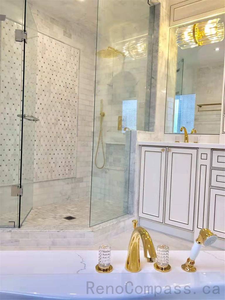 This North York bathroom renovation features a modern glass walk-in shower with marble-look wall tiles and mosaic accent details, paired with a custom vanity, quartz countertop, and elegant gold fixtures. The bright and refined layout enhances both functionality and luxury, creating a timeless and comfortable bathroom space. Completed by a professional Toronto renovation company specializing in high-end residential renovations.