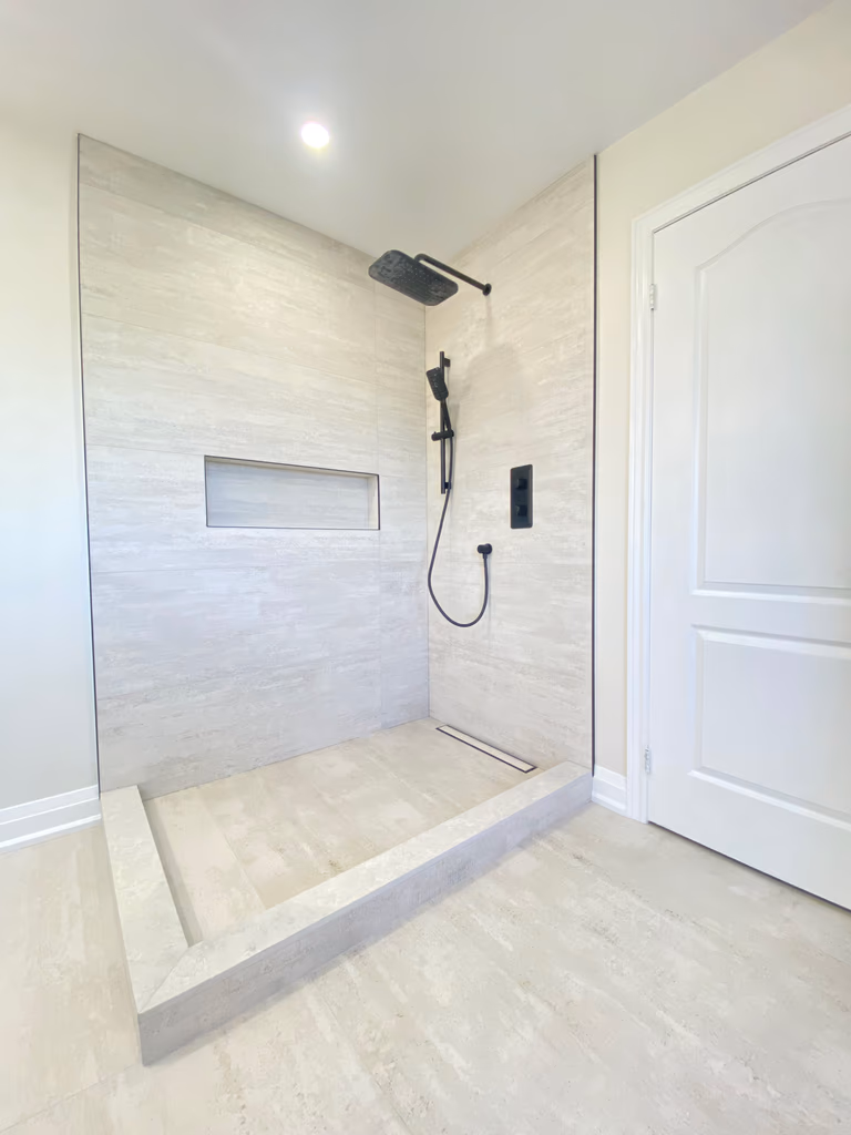 A modern walk-in shower completed as part of a Richmond Hill interior renovation project. This bathroom renovation features a curbless shower base, large-format wall tiles, built-in niche storage, and matte black shower fixtures for a clean and functional finish. Designed and built by Reno Compass, the space emphasizes durability, accessibility, and contemporary bathroom design for homes across Richmond Hill and the Greater Toronto Area.