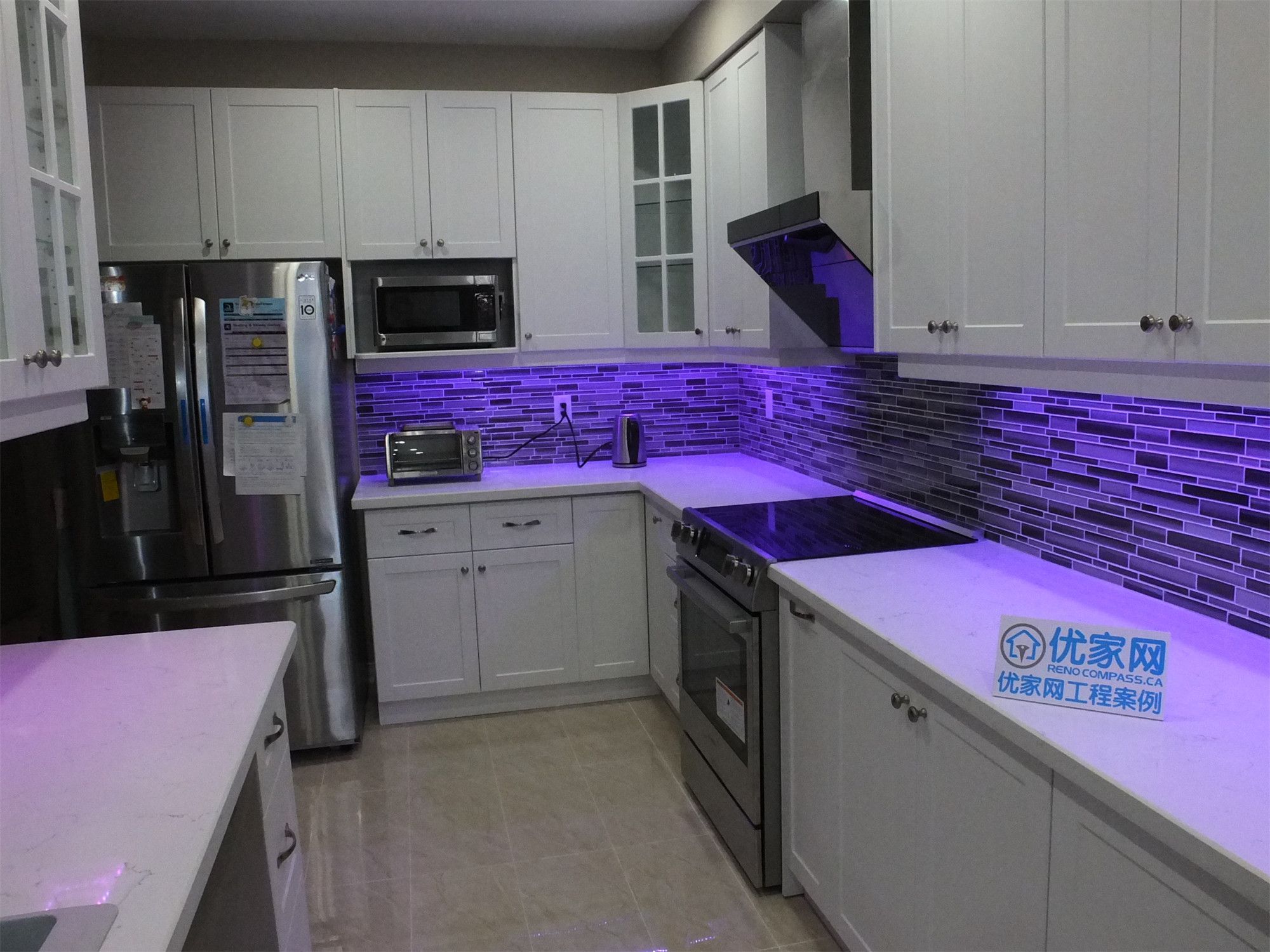 This modern kitchen renovation project in Vaughan features elegant white cabinetry, quartz countertops, stainless steel appliances, and a contemporary mosaic tile backsplash with integrated LED lighting. Completed by a professional Toronto renovation team, the design enhances both functionality and style, creating a bright and sophisticated cooking space for everyday living.