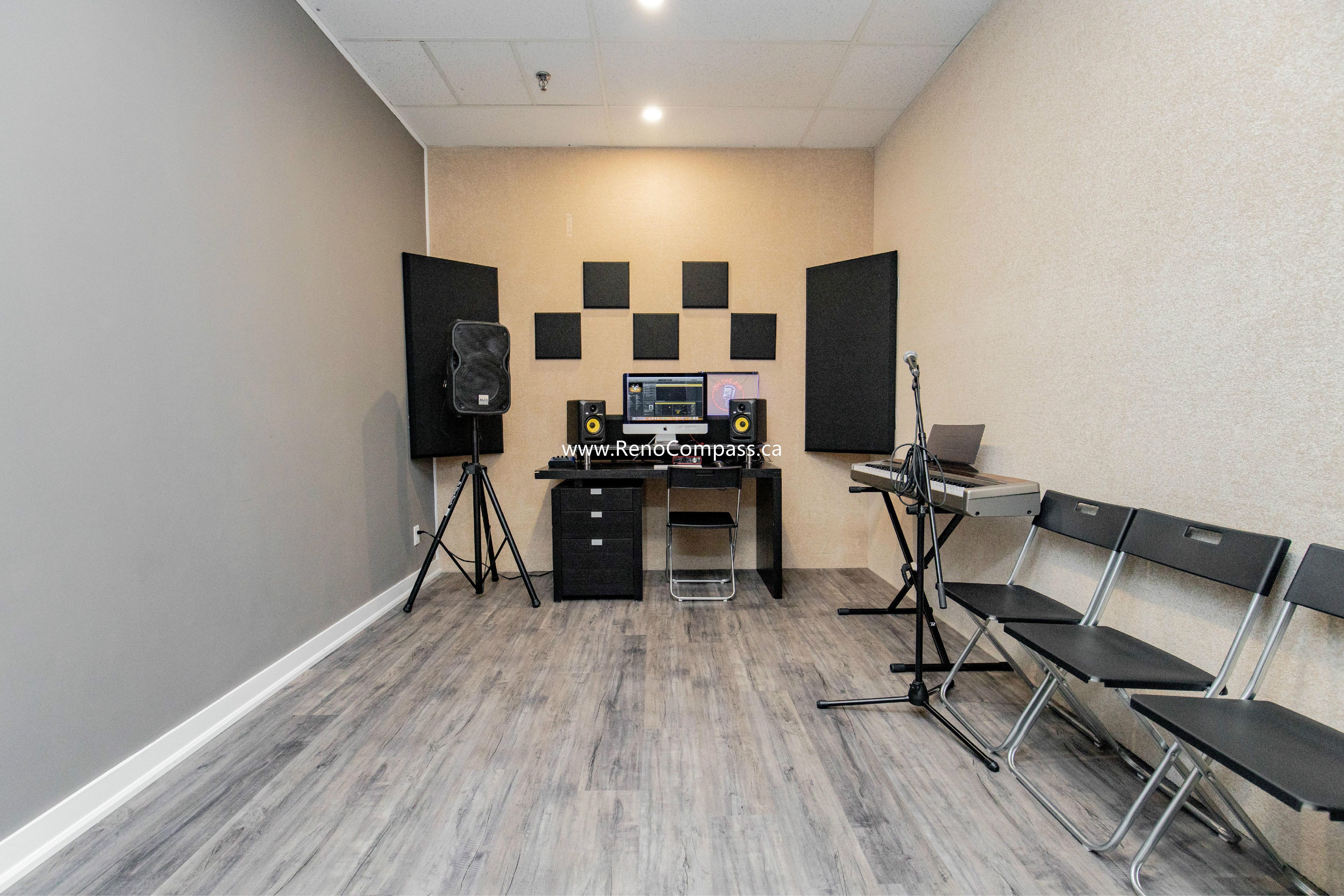 Professional interior renovation of a music production studio at The Singing School. This Richmond Hill project features custom-mounted acoustic foam panels, durable grey wood-grain laminate flooring, and recessed pot lighting. Expertly designed for both sound quality and commercial durability.