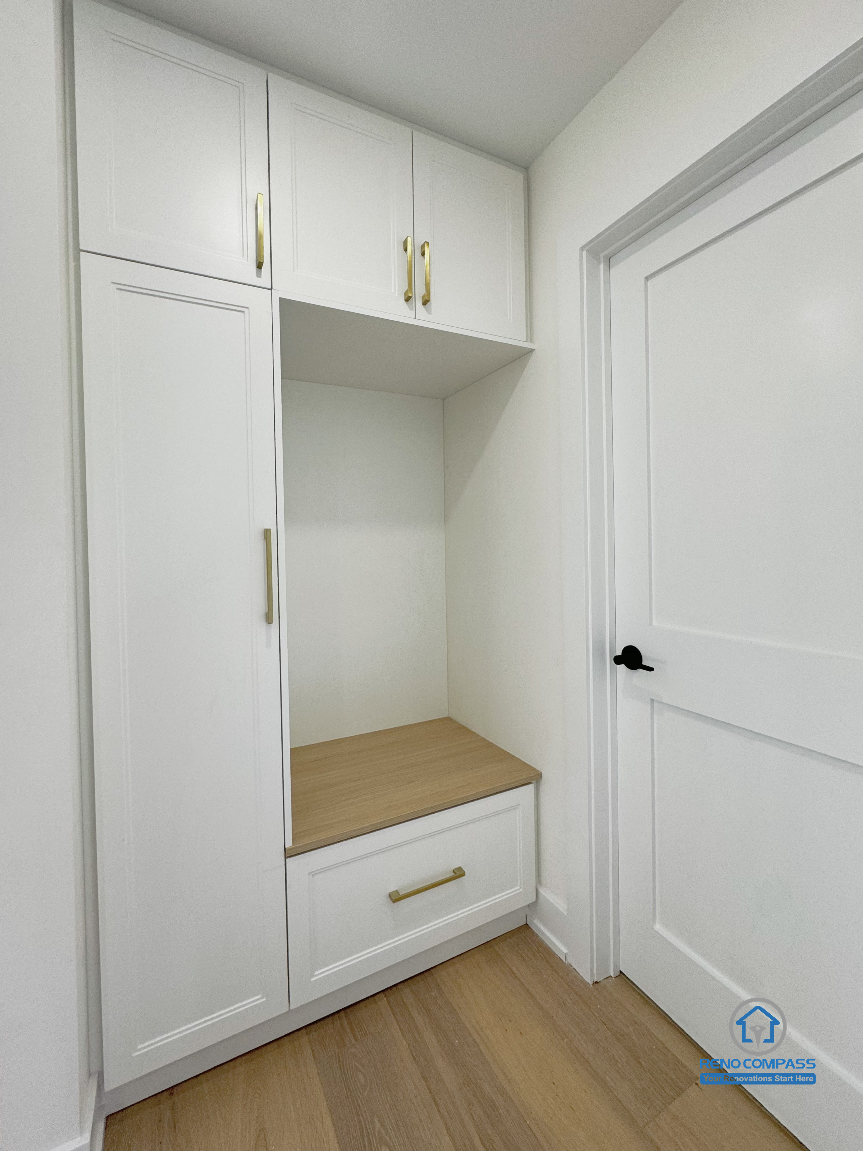 This Richmond Hill interior renovation features a custom built-in storage cabinet designed with integrated bench seating and concealed upper and lower cabinetry. The clean white finish paired with warm wood tones enhances both functionality and visual balance, making it ideal for entryway or transitional spaces. Thoughtfully planned for everyday storage and organization, this built-in solution reflects a Toronto renovation approach focused on practical design, space efficiency, and long-term usability.