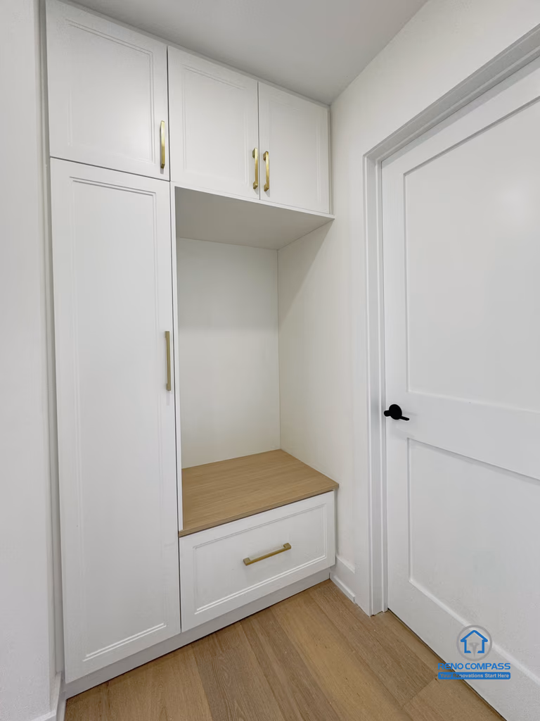 This Richmond Hill interior renovation features a custom built-in storage cabinet designed with integrated bench seating and concealed upper and lower cabinetry. The clean white finish paired with warm wood tones enhances both functionality and visual balance, making it ideal for entryway or transitional spaces. Thoughtfully planned for everyday storage and organization, this built-in solution reflects a Toronto renovation approach focused on practical design, space efficiency, and long-term usability.