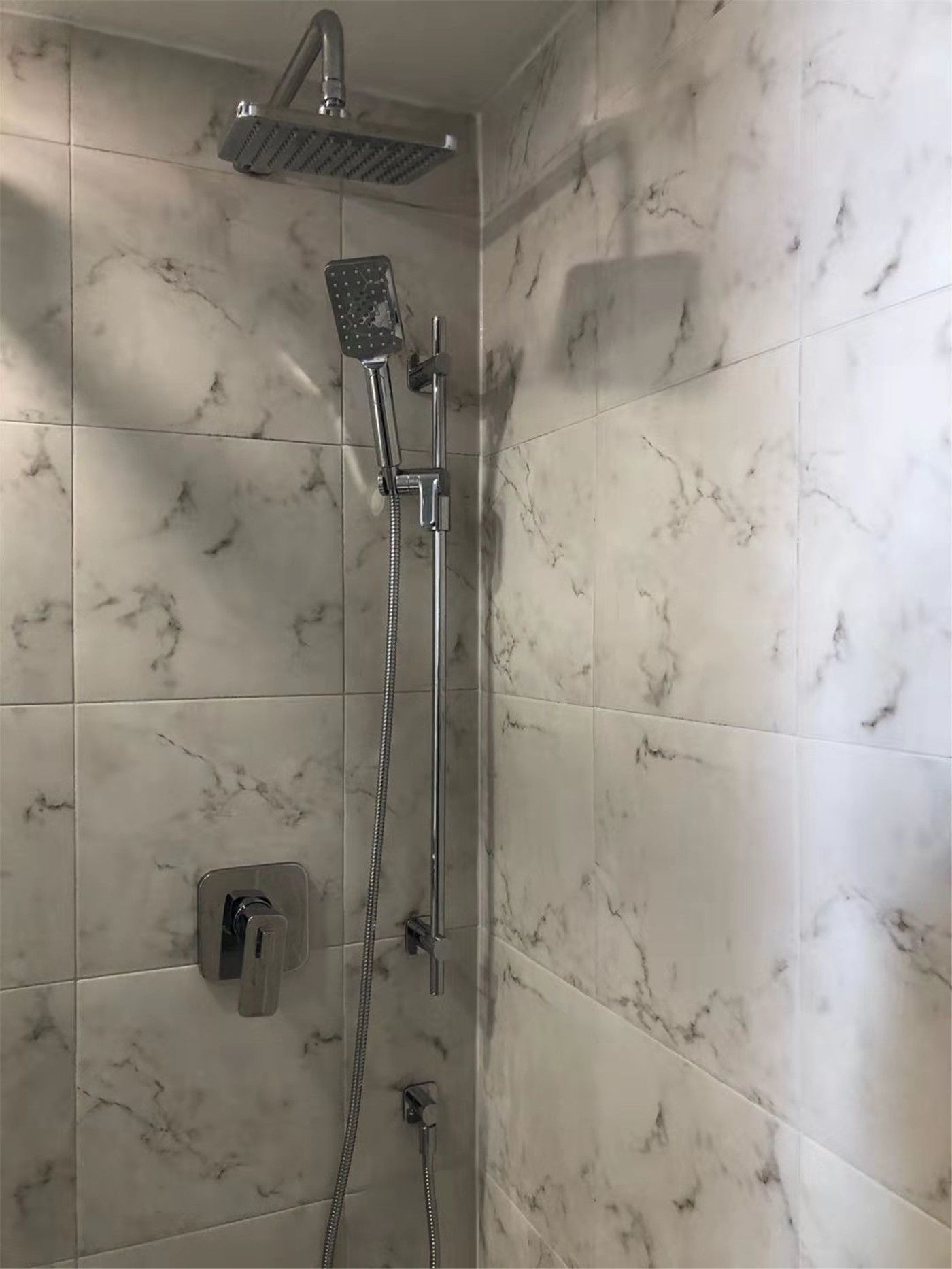 This Richmond Hill bathroom renovation features a modern marble-look tile shower with a sleek rainfall showerhead, handheld system, and minimalist chrome fixtures. Designed for comfort and durability, the upgraded shower space combines elegant finishes with functional layout improvements. Completed by a professional Toronto renovation company, this project delivers a clean, contemporary bathroom built for long-term use and everyday luxury.