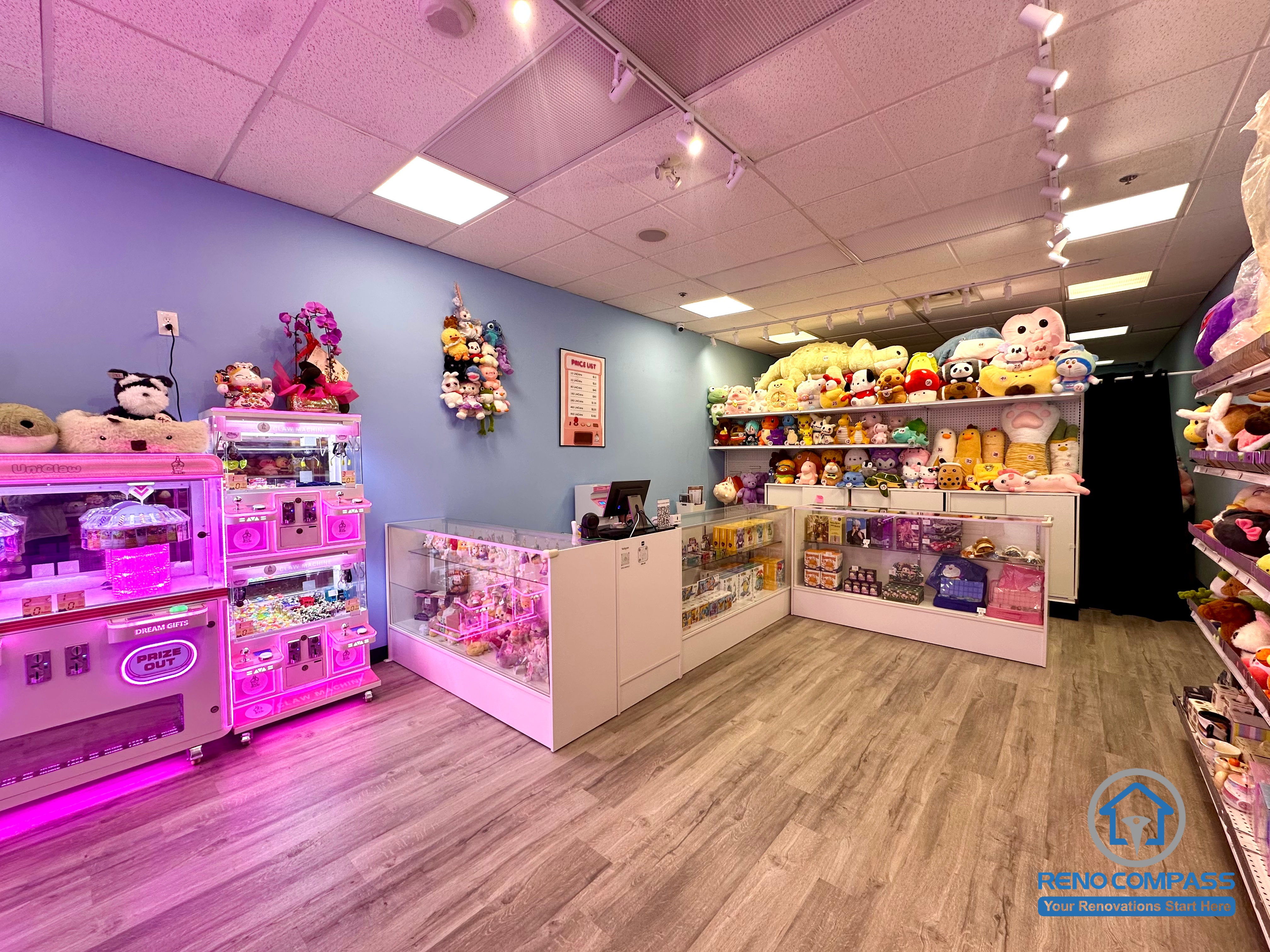 Prize display shelves and checkout counter inside an arcade claw machine store at Oakville Place Mall. The layout combines arcade gaming machines with retail prize displays, creating an indoor playground-style entertainment environment for visitors.