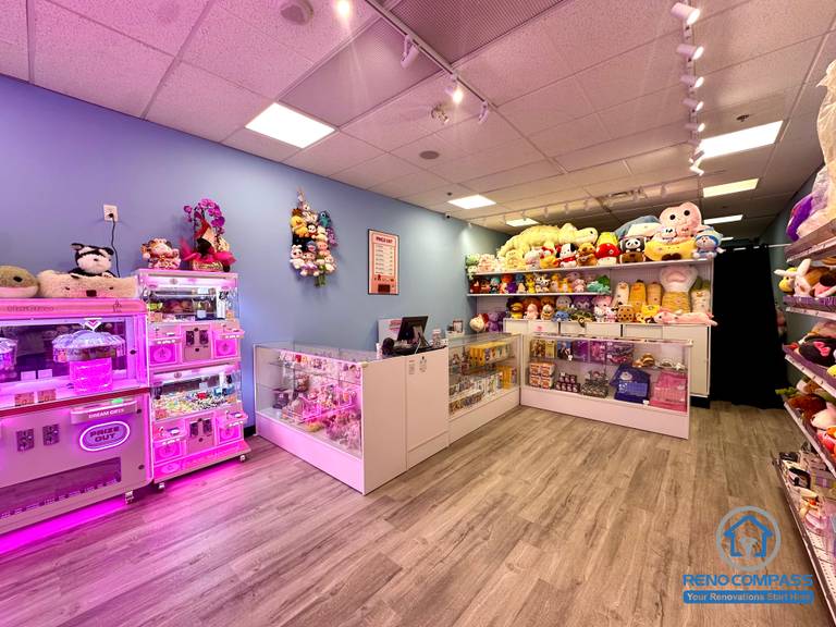 Prize display shelves and checkout counter inside an arcade claw machine store at Oakville Place Mall. The layout combines arcade gaming machines with retail prize displays, creating an indoor playground-style entertainment environment for visitors.