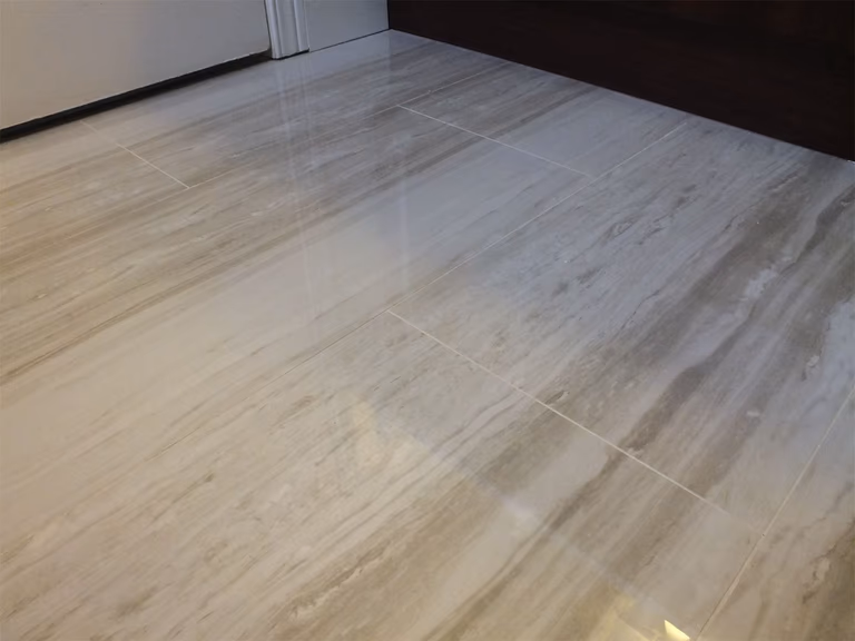 This image highlights the bathroom floor tile installation as part of a North York interior renovation. The large-format tiles are laid with precise alignment and clean grout lines, creating a smooth, durable surface that enhances both visual continuity and everyday functionality. The neutral stone texture complements the overall bathroom design while ensuring easy maintenance and long-term performance.