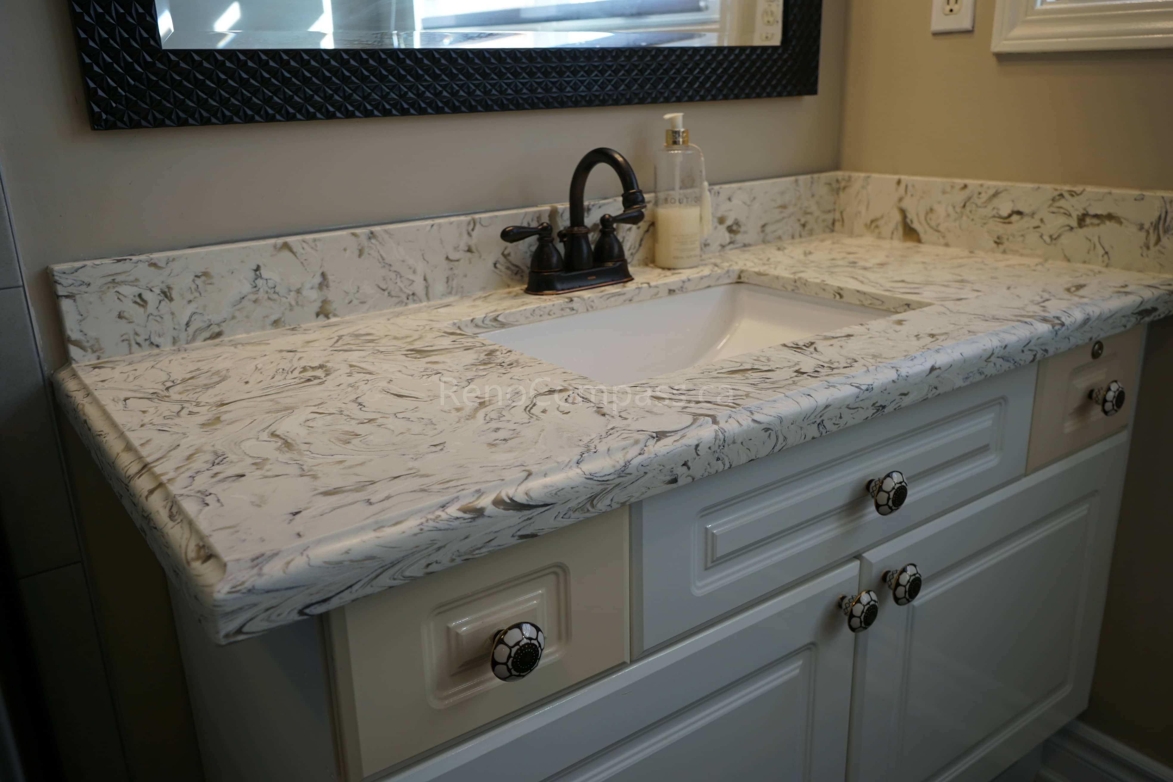 This  bathroom renovation highlights a custom vanity featuring a durable quartz countertop with elegant veining and an undermount sink. The matte black faucet and hardware add a modern contrast, while the upgraded cabinetry enhances storage and style. This refined design brings both functionality and timeless appeal to the updated bathroom space.