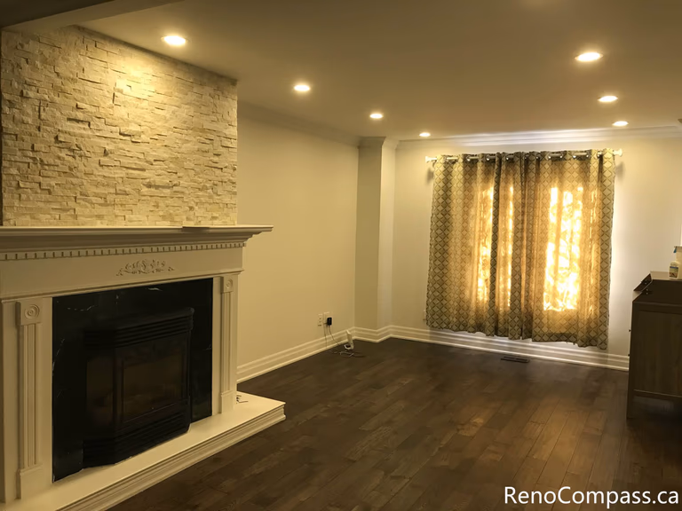 This Mississauga interior renovation highlights a bright bay window living space enhanced with custom curtain installation, detailed trim work, and rich hardwood flooring. The upgraded windows improve natural light control while adding warmth and elegance to the room. Completed by a trusted Toronto renovation company, Reno Compass Inc., this project showcases refined interior finishing and professional craftsmanship.