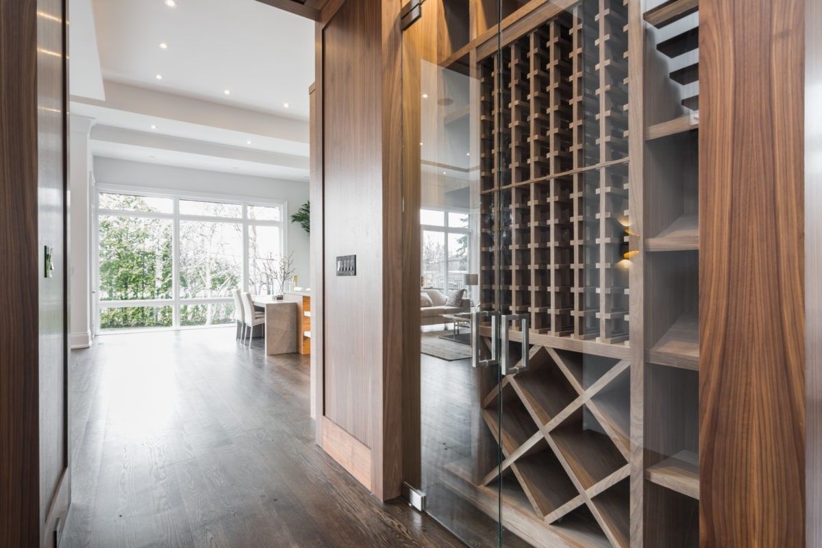This 4,500 sq ft modern interior renovation in Toronto features a custom-built glass wine cabinet with warm wood millwork and sleek architectural detailing. The transparent enclosure enhances spatial flow while adding a refined focal point to the open-concept layout. Designed and built by a professional Toronto Renovation Company, Reno Compass Inc., this project reflects luxury craftsmanship and thoughtful space planning.