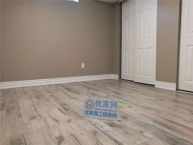 This image shows a finished room within a Toronto basement renovation, featuring durable vinyl plank flooring and neutral painted walls. Clean baseboard detailing and sliding closet doors provide a polished, functional look suitable for a bedroom, home office, or flex space. The simple layout allows for flexible furniture placement while maintaining comfort and practicality. This basement renovation demonstrates the attention to detail and finishing quality delivered by a professional Toronto renovation company.