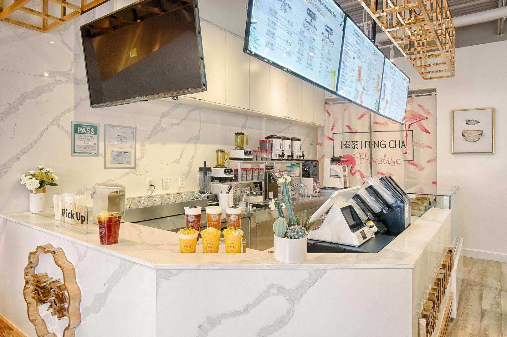 This Toronto milk tea shop renovation features a modern service counter and beverage preparation area designed for both efficiency and visual appeal. The custom marble-style counter, digital menu boards, commercial beverage equipment setup, and optimized workflow layout create a smooth ordering and pick-up experience for customers. Bright lighting, clean finishes, and functional storage solutions ensure the space meets high-traffic commercial needs while maintaining a stylish café atmosphere. Completed by a professional Toronto renovation company, this bubble tea shop interior renovation highlights quality craftsmanship, practical layout planning, and modern commercial design tailored for busy beverage and dessert retail environments.
