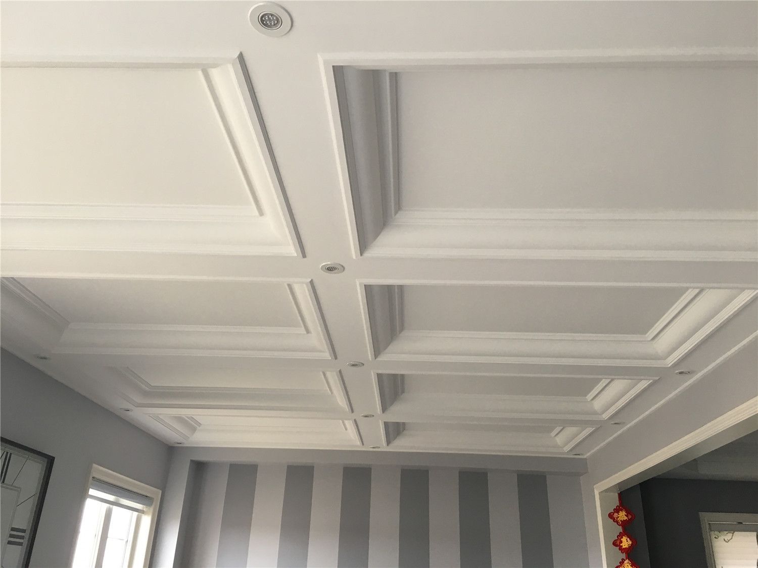 Custom coffered ceiling with recessed lighting installed as part of a Toronto interior renovation project. The detailed ceiling trim and structured panel design add depth, elegance, and architectural character to the living space, completed by a professional Toronto renovation company.