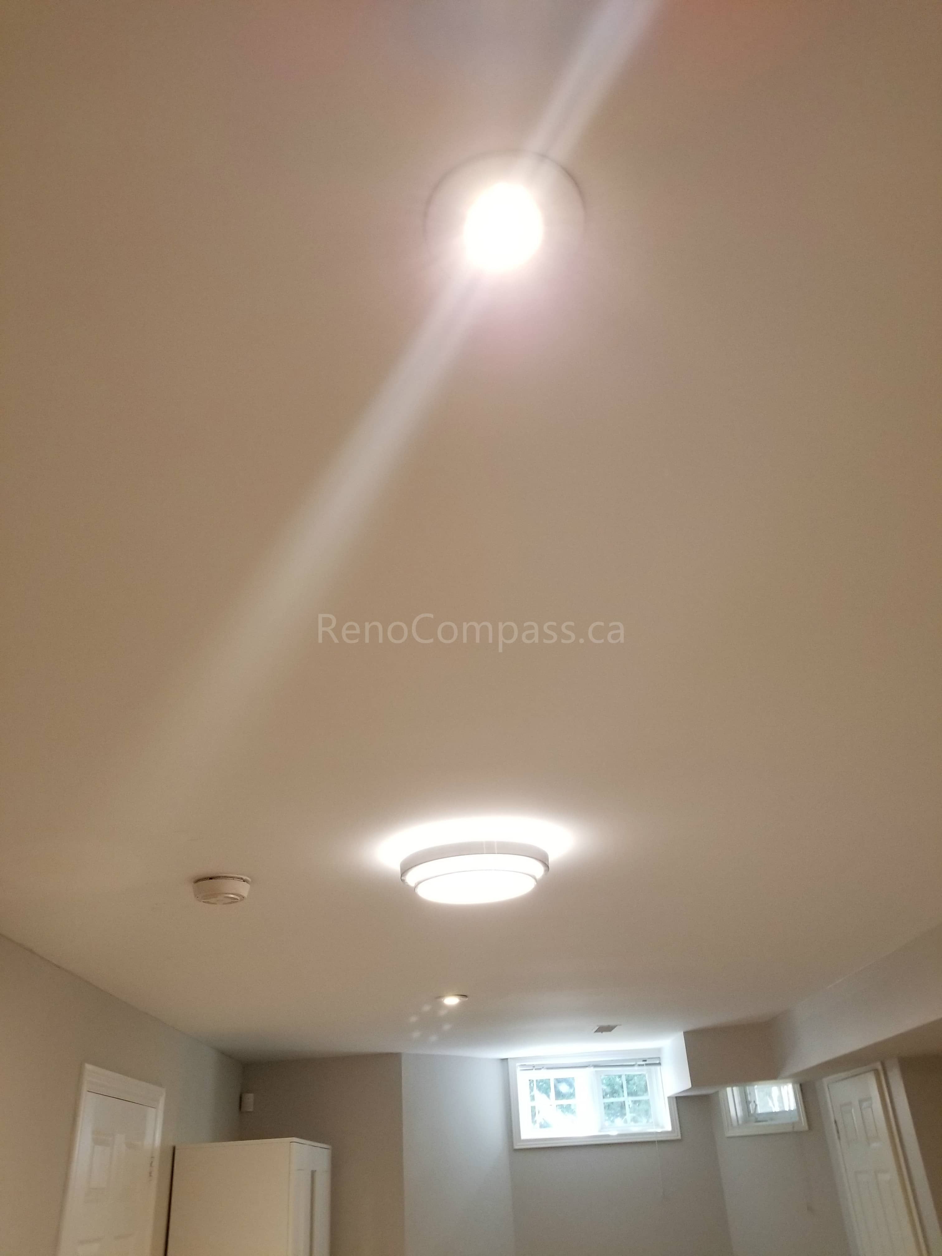 This Toronto basement renovation features newly installed ceiling lighting, including modern pot lights and flush mount fixtures to brighten the entire space. The upgraded lighting design improves visibility, enhances ambiance, and creates a clean, modern basement living environment. Completed by Reno Compass Inc., this lighting installation adds both functionality and contemporary style to the finished basement.