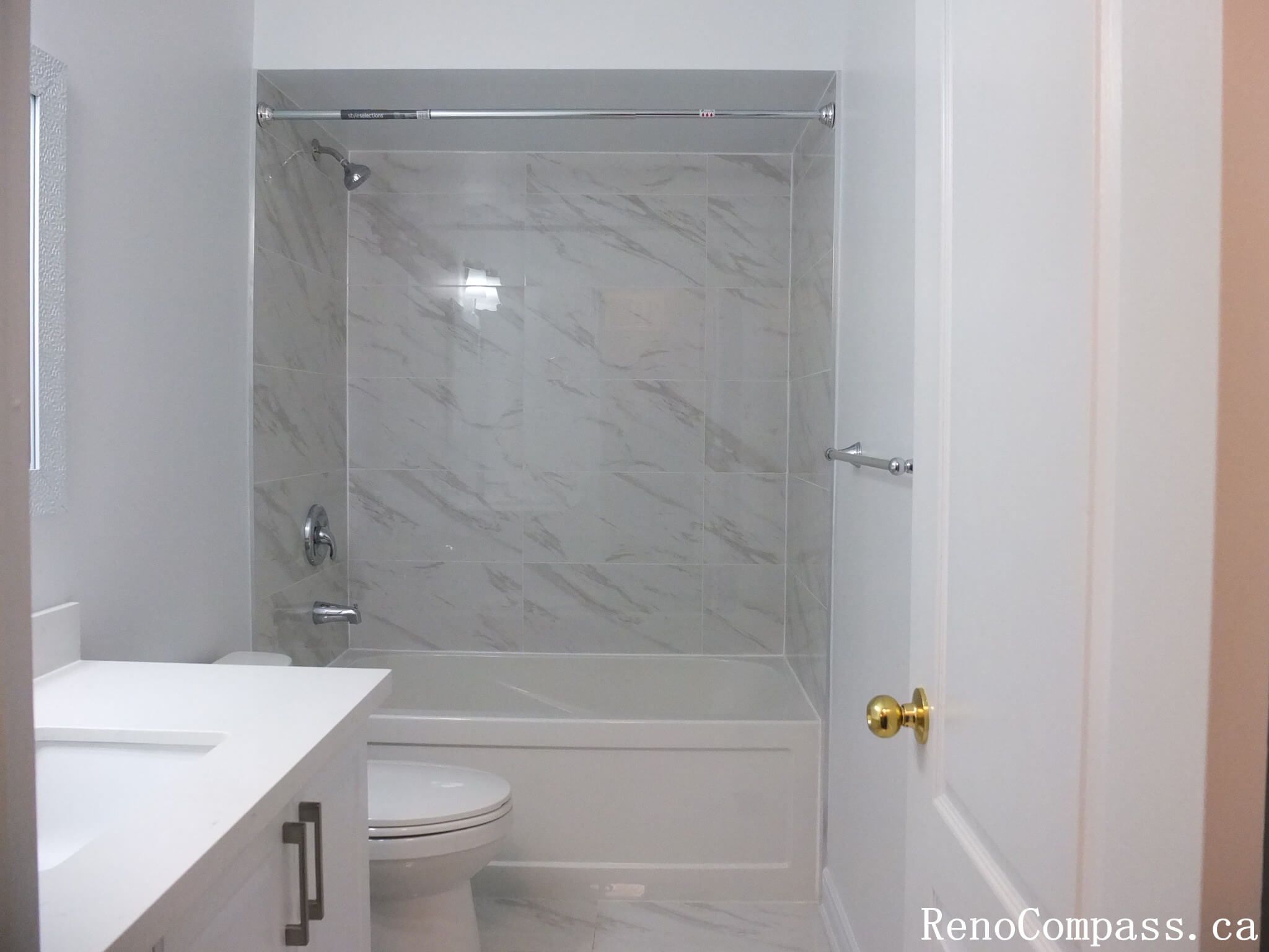This Richmond Hill bathroom renovation features a clean tub-shower combination with marble-look wall tiles, modern glass doors, and a sleek vanity. Completed by a professional Toronto renovation company, the layout maximizes functionality while maintaining a bright and contemporary aesthetic. Neutral finishes and durable materials create a fresh, low-maintenance bathroom designed for everyday comfort and long-term use.