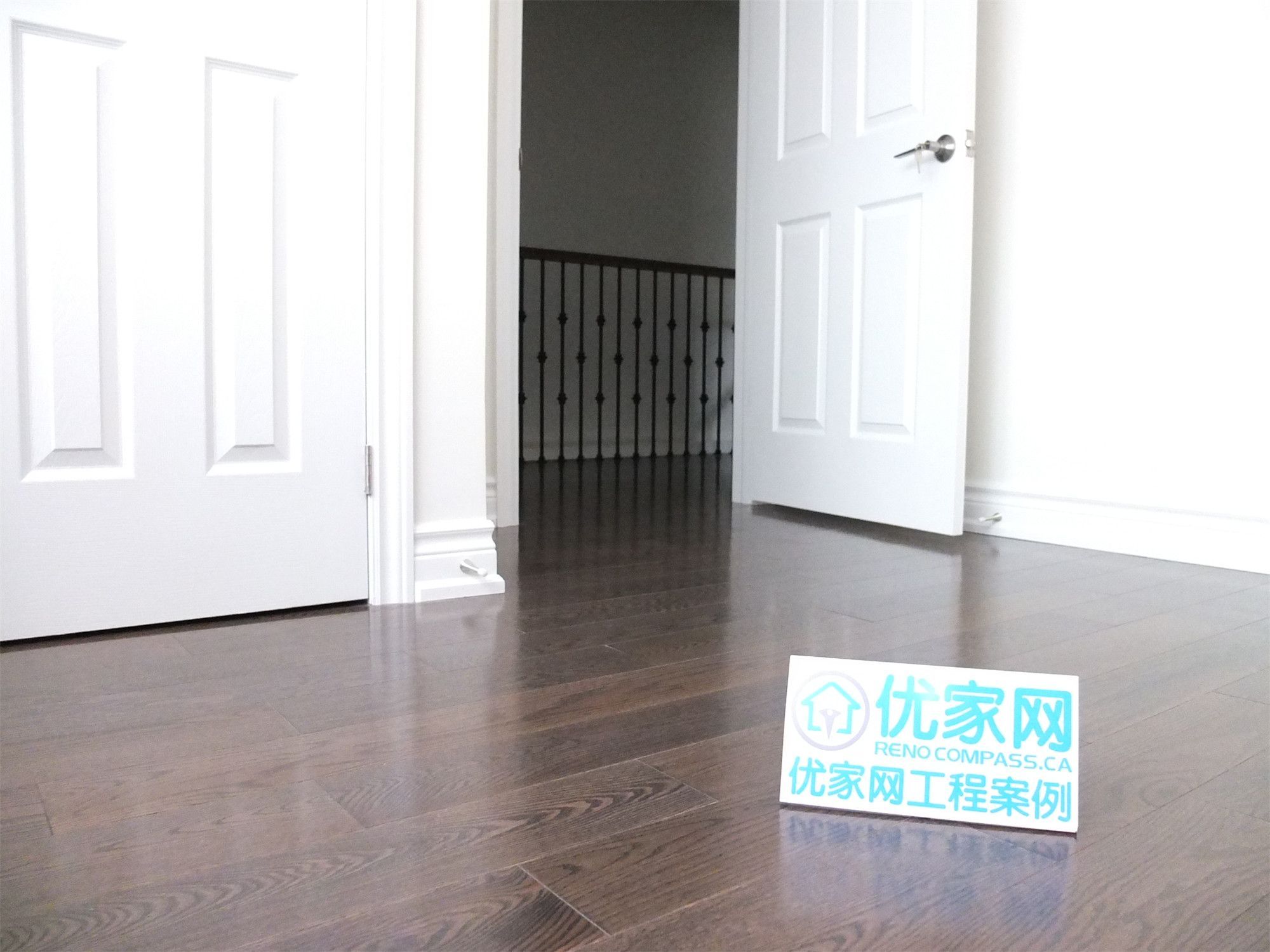 Interior hallway view from a Scarborough home addition project featuring newly installed dark hardwood flooring, clean white doors, and modern trim finishes. The renovation improves interior flow and creates a bright, polished living space within the expanded home layout.