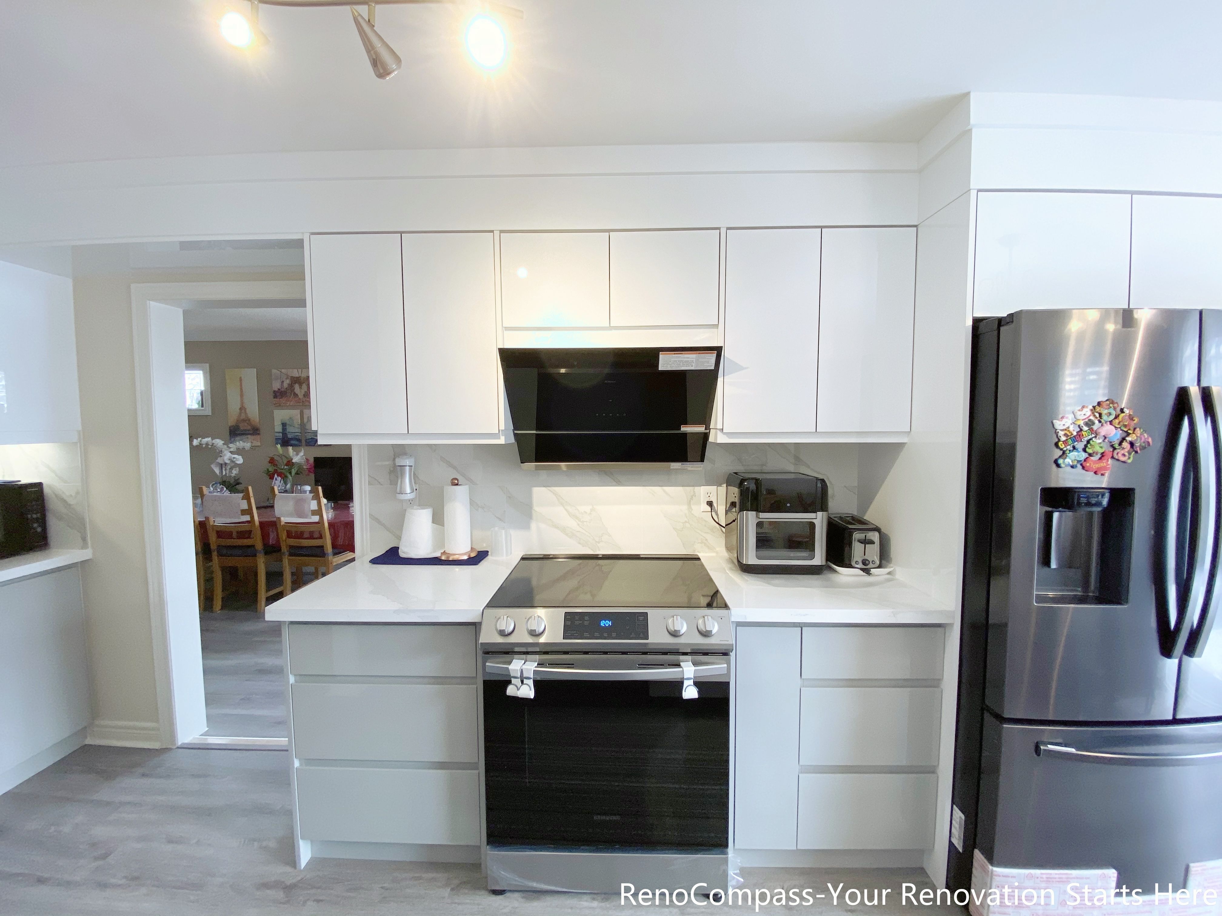 This image presents a modern kitchen renovation in Mississauga featuring full-height white cabinetry, integrated upper storage, and a clean appliance wall layout. The kitchen includes a stainless steel range, built-in hood, quartz countertops, and energy-efficient appliances, creating a balanced mix of functionality and visual clarity. Consistent cabinetry lines and neutral finishes improve workflow and storage efficiency, while the open layout supports everyday cooking and family use. This design reflects a practical and timeless approach to Mississauga kitchen renovations.