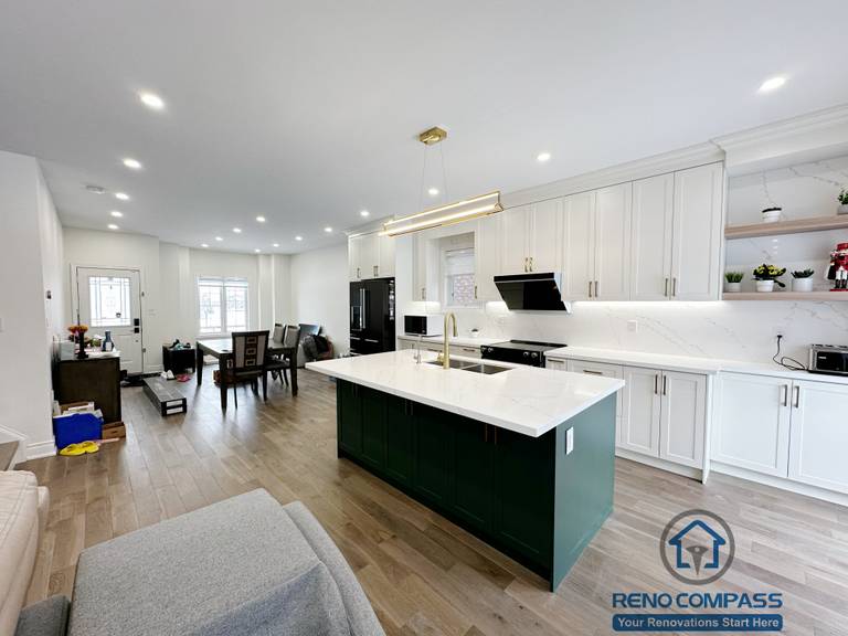 Open-concept interior renovation in Markham featuring a modern kitchen with white cabinetry, quartz countertops, a contrasting green island, and seamless connection to the living area. The layout improves circulation, natural light, and everyday functionality.
