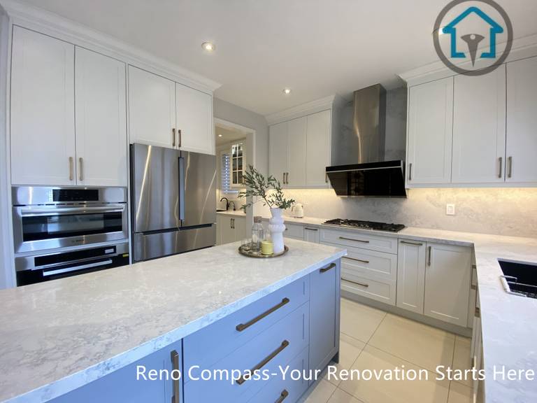 This image highlights the kitchen island and built-in appliance wall in this Markham kitchen renovation. Custom cabinetry integrates a refrigerator and wall oven seamlessly, while the central island provides additional prep space and storage. The balanced layout and consistent finishes create a clean, cohesive kitchen designed for everyday use. Designed and completed by Reno Compass, this project reflects a refined and practical approach to kitchen renovation in Markham.