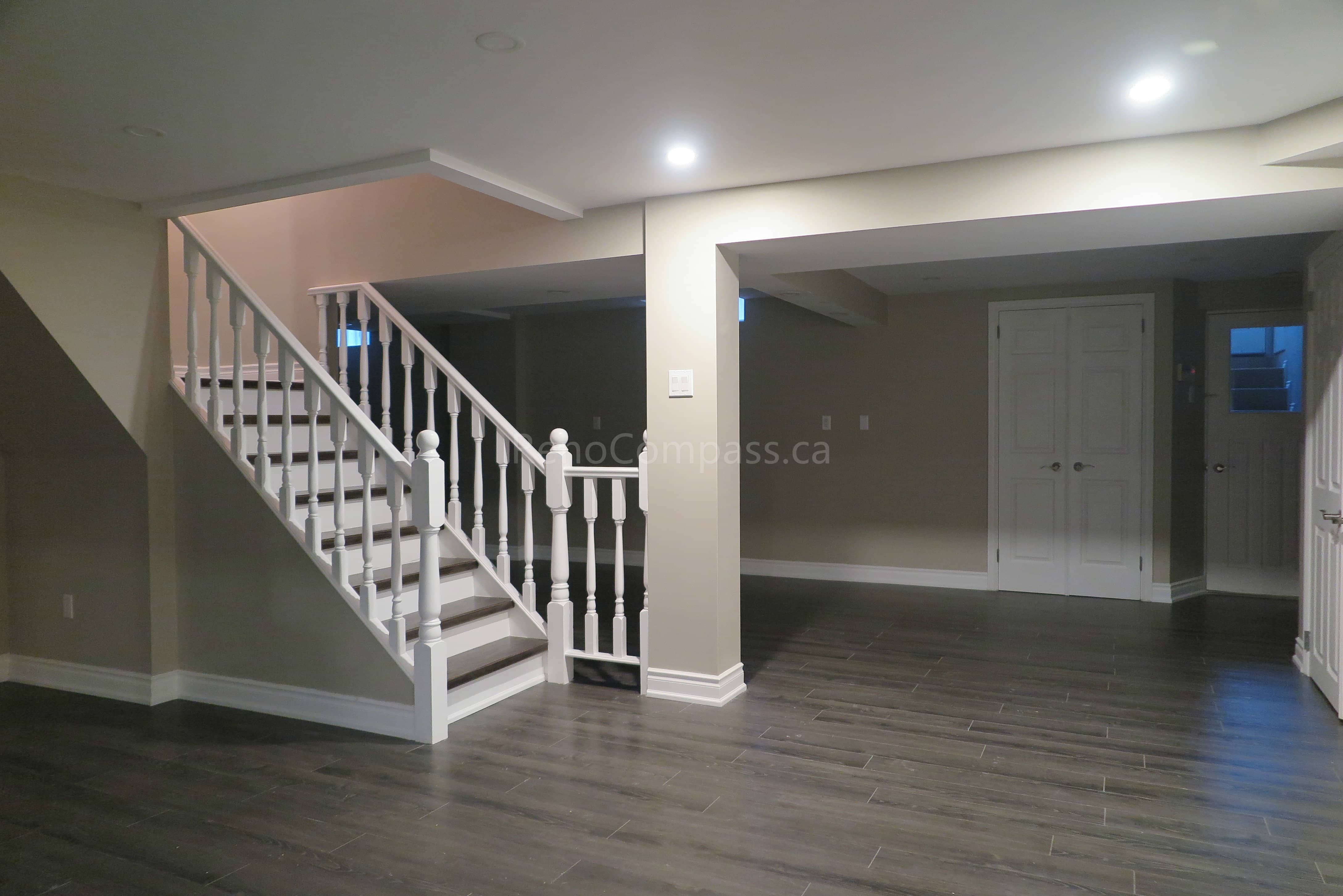 This Markham basement renovation features a spacious open-concept layout with newly installed modern flooring, fresh neutral paint, and upgraded staircase with white railings and trim detailing. Recessed LED lighting enhances brightness throughout the lower level, creating a functional and welcoming space ideal for a family lounge, recreation area, or rental suite potential. Completed by Reno Compass, a professional renovation contractor delivering high-quality basement finishing and interior renovation services across Markham and the Greater Toronto Area.