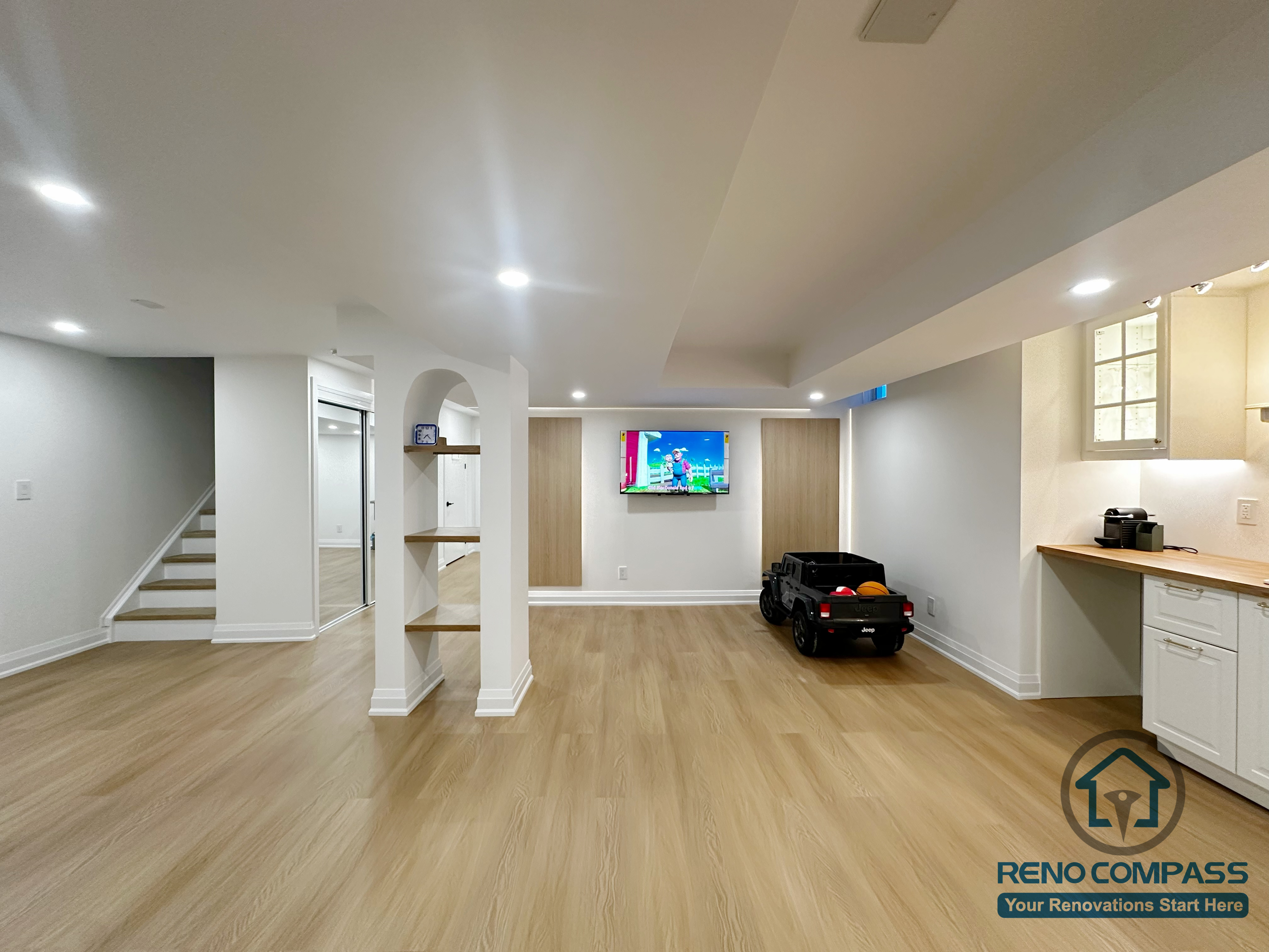 Open-concept basement renovation in Markham featuring light wood flooring, recessed ceiling lighting, and clean white support columns. The layout improves brightness, structural clarity, and flexibility for family living, recreation, and future customization.