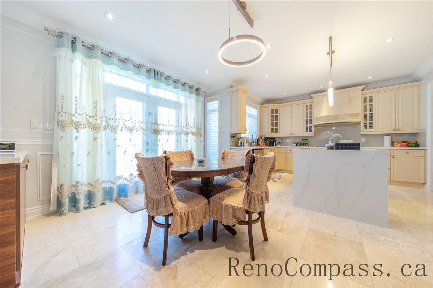 This Richmond Hill entire house interior renovation highlights an elegant open-concept dining and living area featuring rich hardwood flooring, custom ceiling detailing, and decorative columns. Large windows and a bright foyer connection enhance natural light and spatial flow throughout the home. The refined layout and timeless finishes create a warm, luxurious atmosphere, professionally completed by a leading Toronto renovation company focused on quality craftsmanship and modern functionality.
